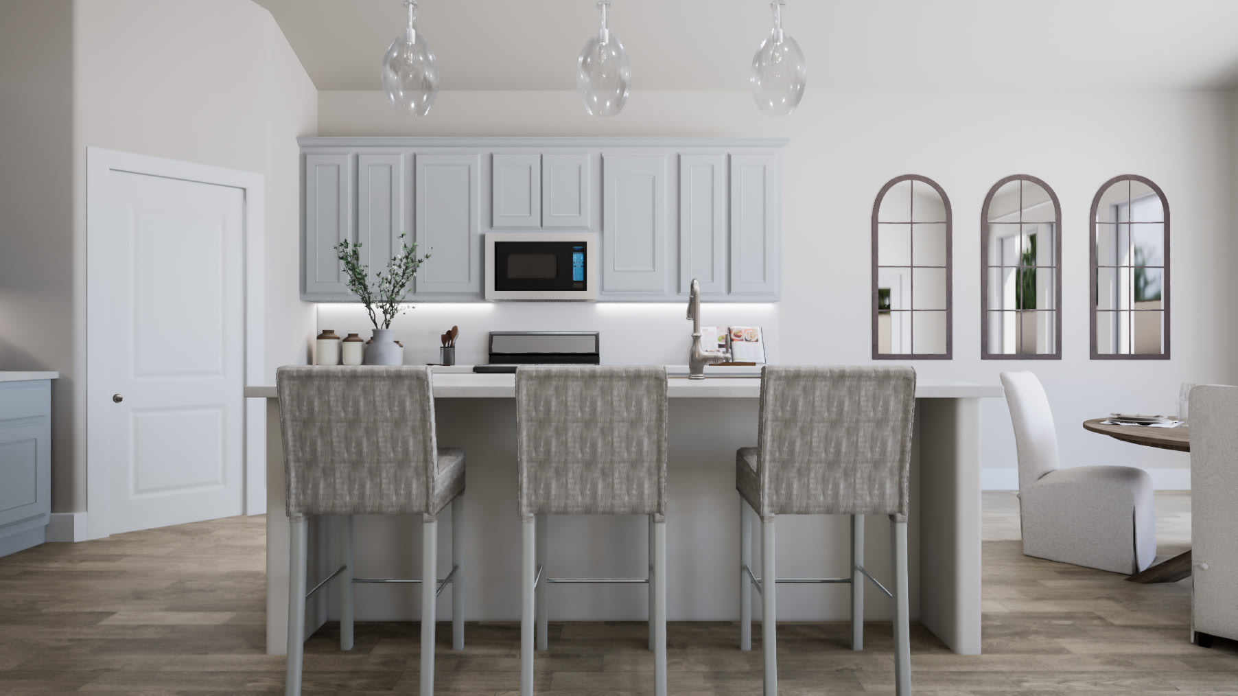 A modern and minimalist kitchen with white cabinetry, gray bar stools, and arched mirrors on the wall, set against a light-colored hardwood floor.