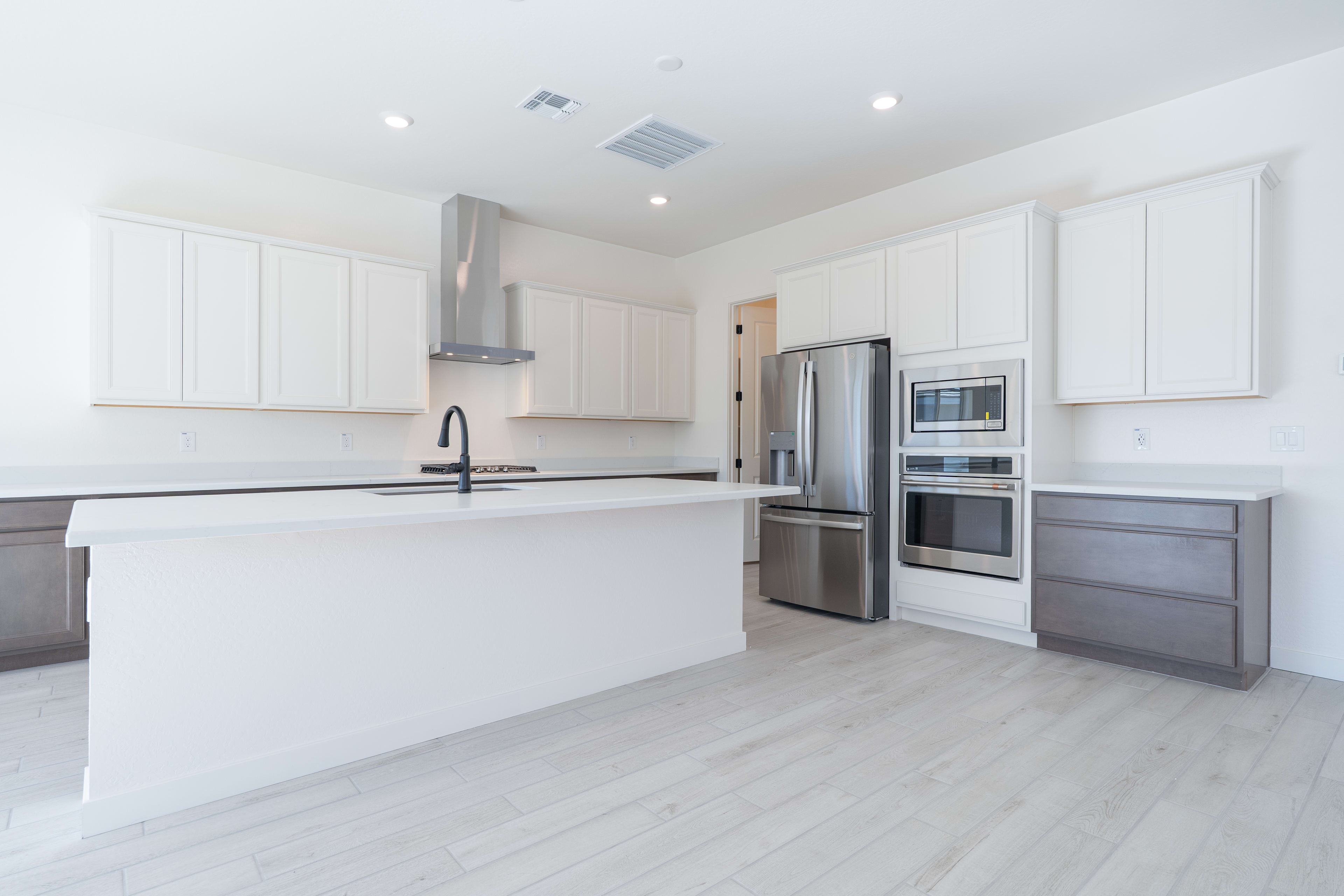 A modern, well-lit kitchen with white cabinets, stainless steel appliances, and a sleek, minimalist design.