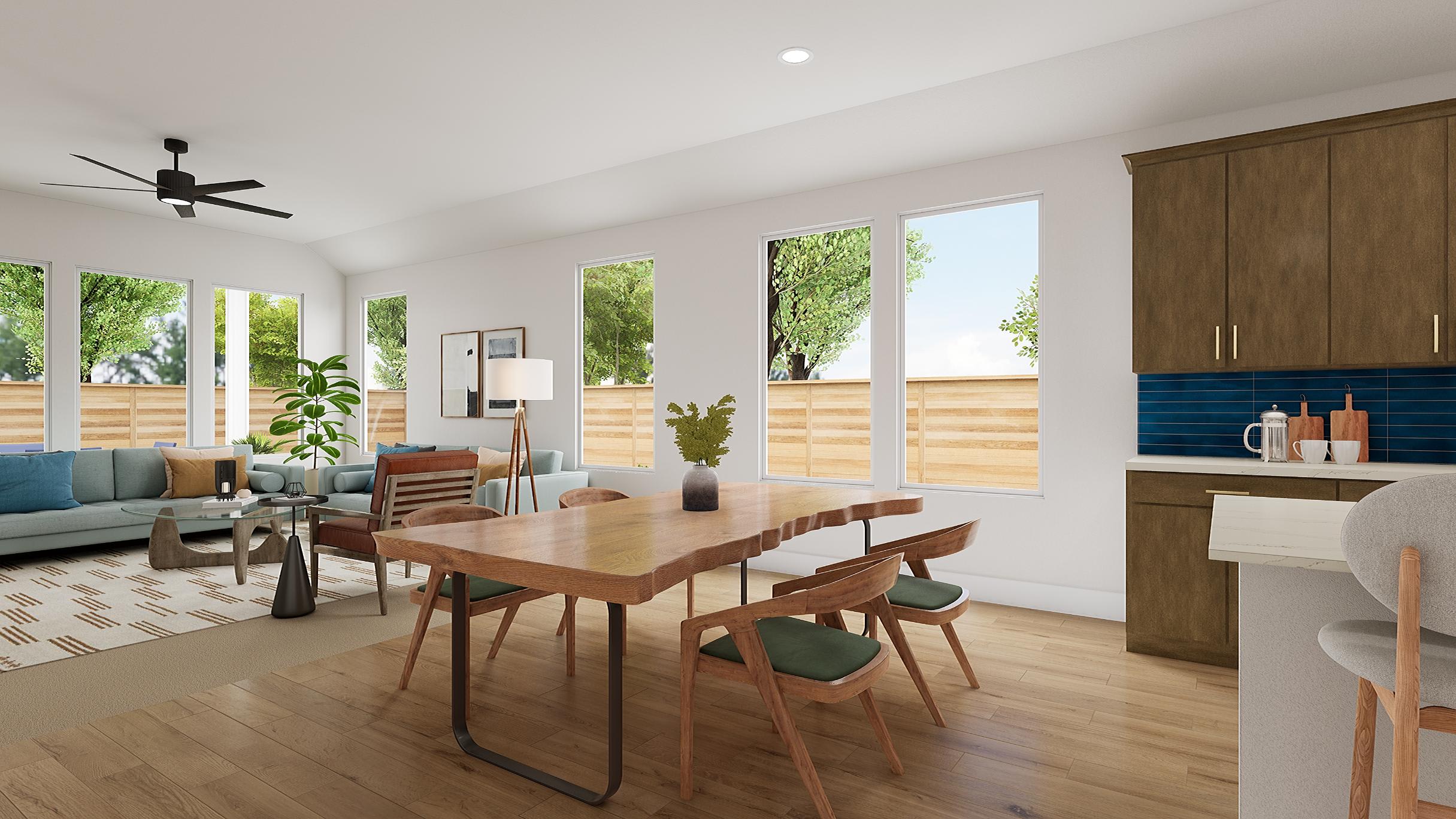 A modern, open-concept living and dining area with large windows overlooking a lush, green outdoor space.