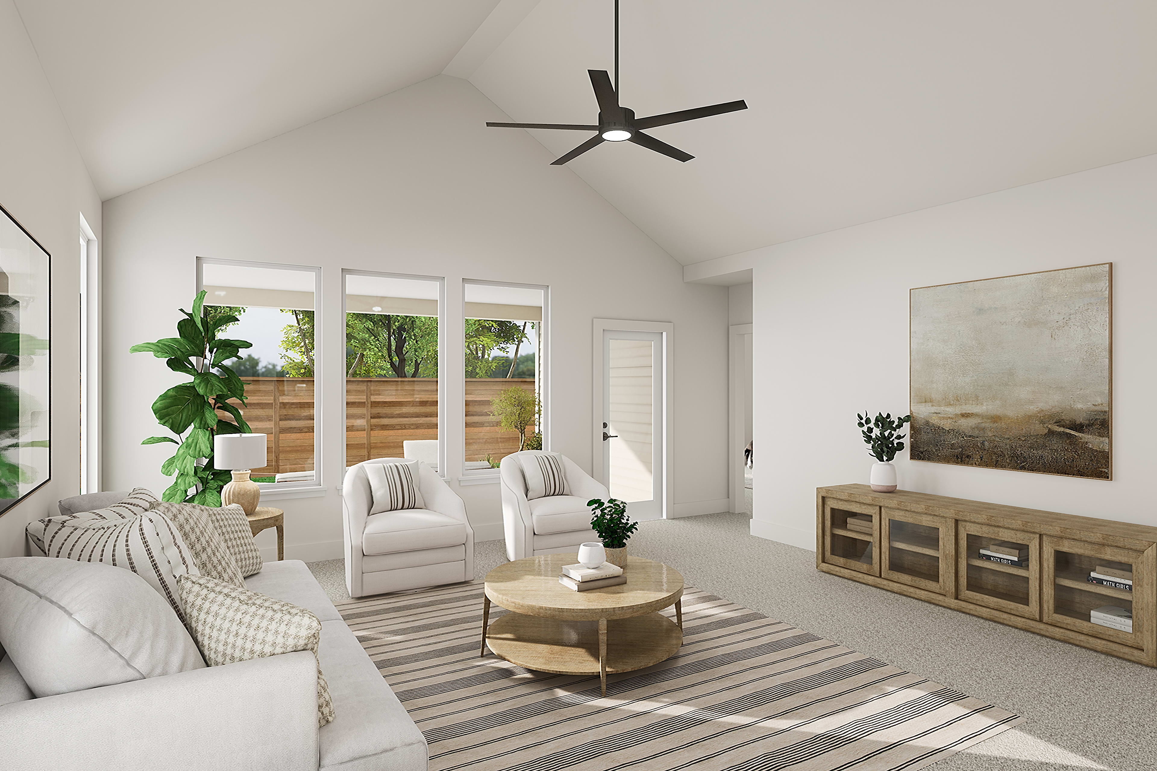 A bright and airy living room with a vaulted ceiling, featuring a modern ceiling fan, plush white furniture, and a wooden cabinet against the wall, surrounded by large windows overlooking a lush outdoor scene.