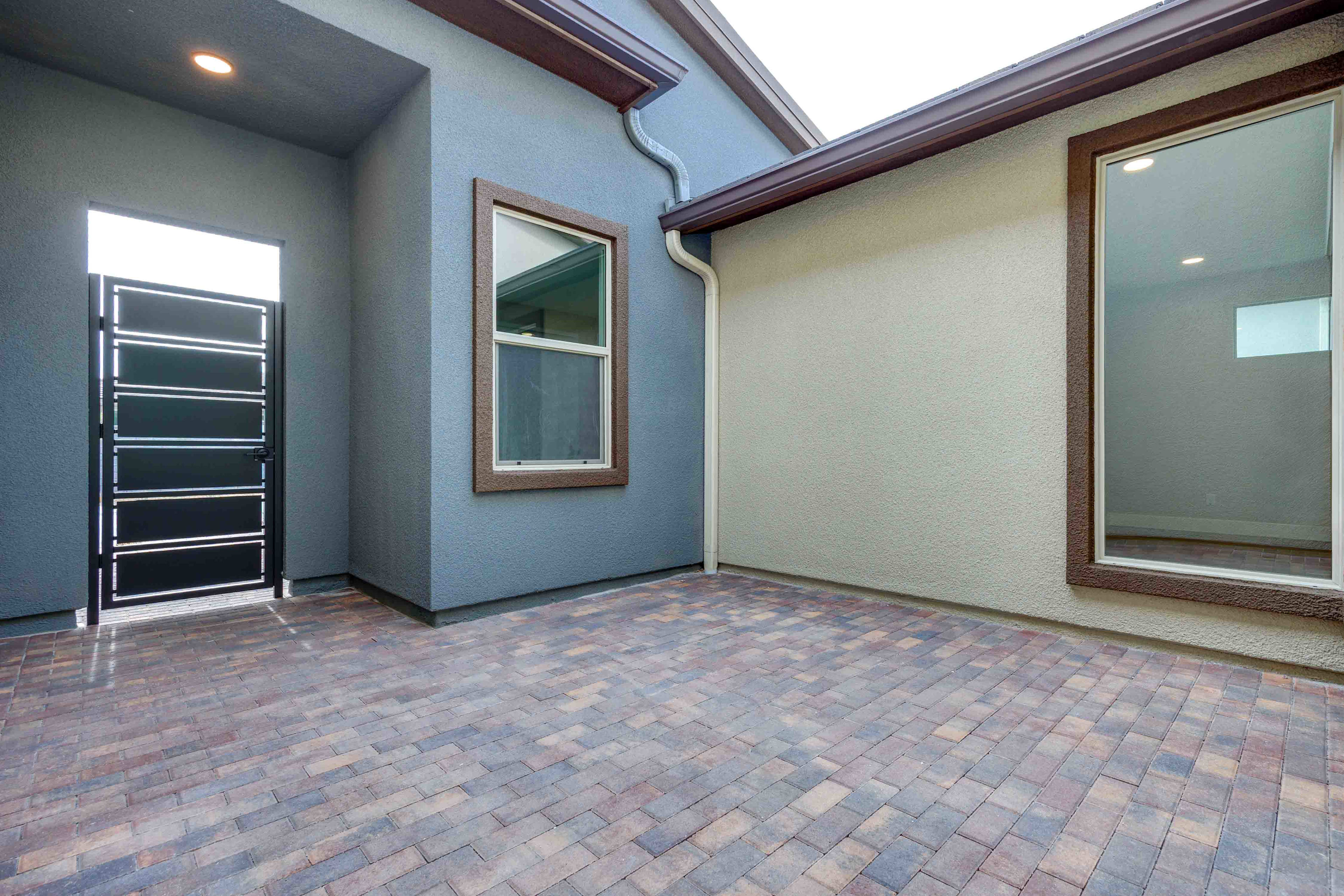 A spacious entryway with a brick-patterned floor, wooden trim, and a large mirror on the wall.