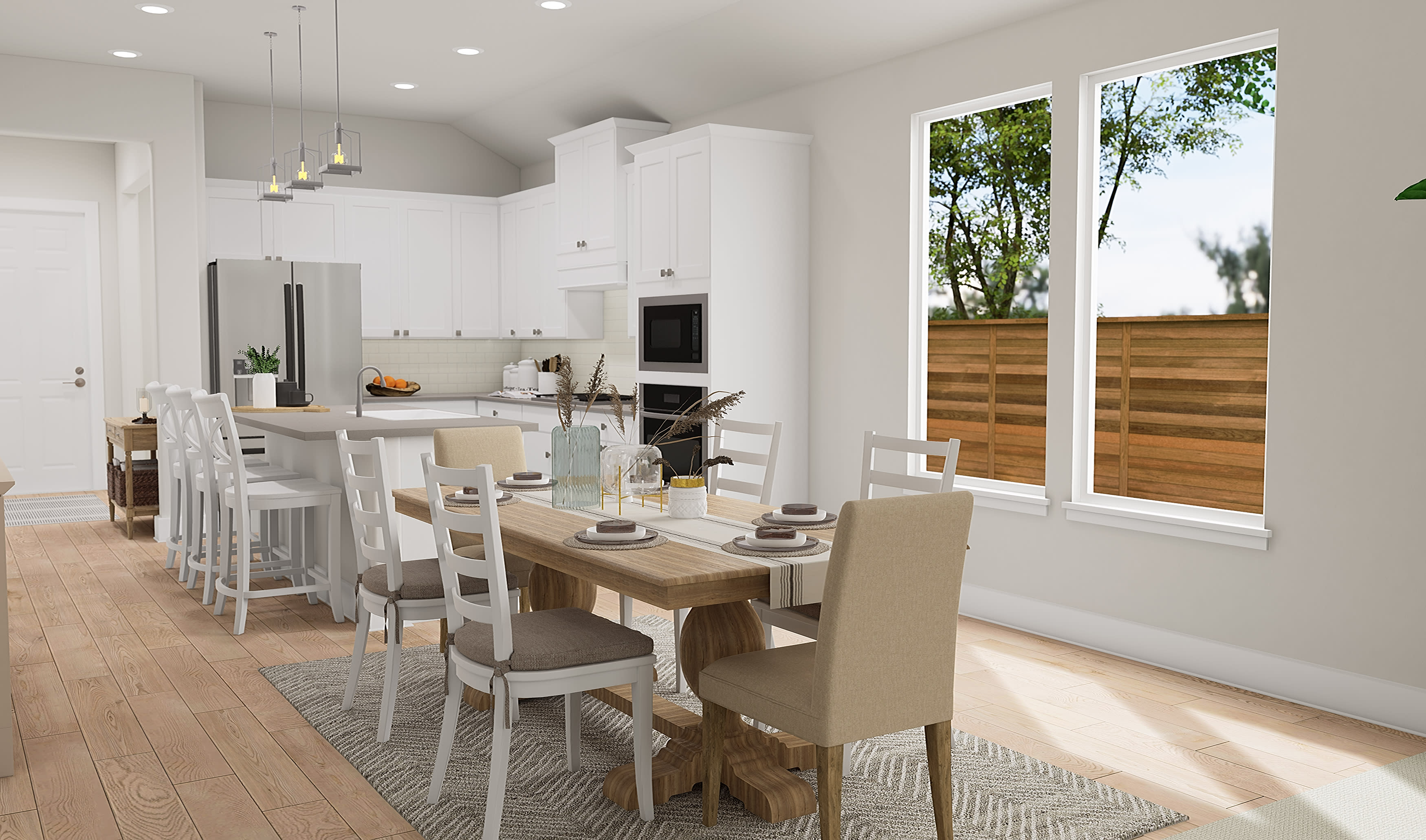 A modern, open-concept kitchen and dining area with a wooden table, white chairs, and large windows overlooking a backyard with trees.