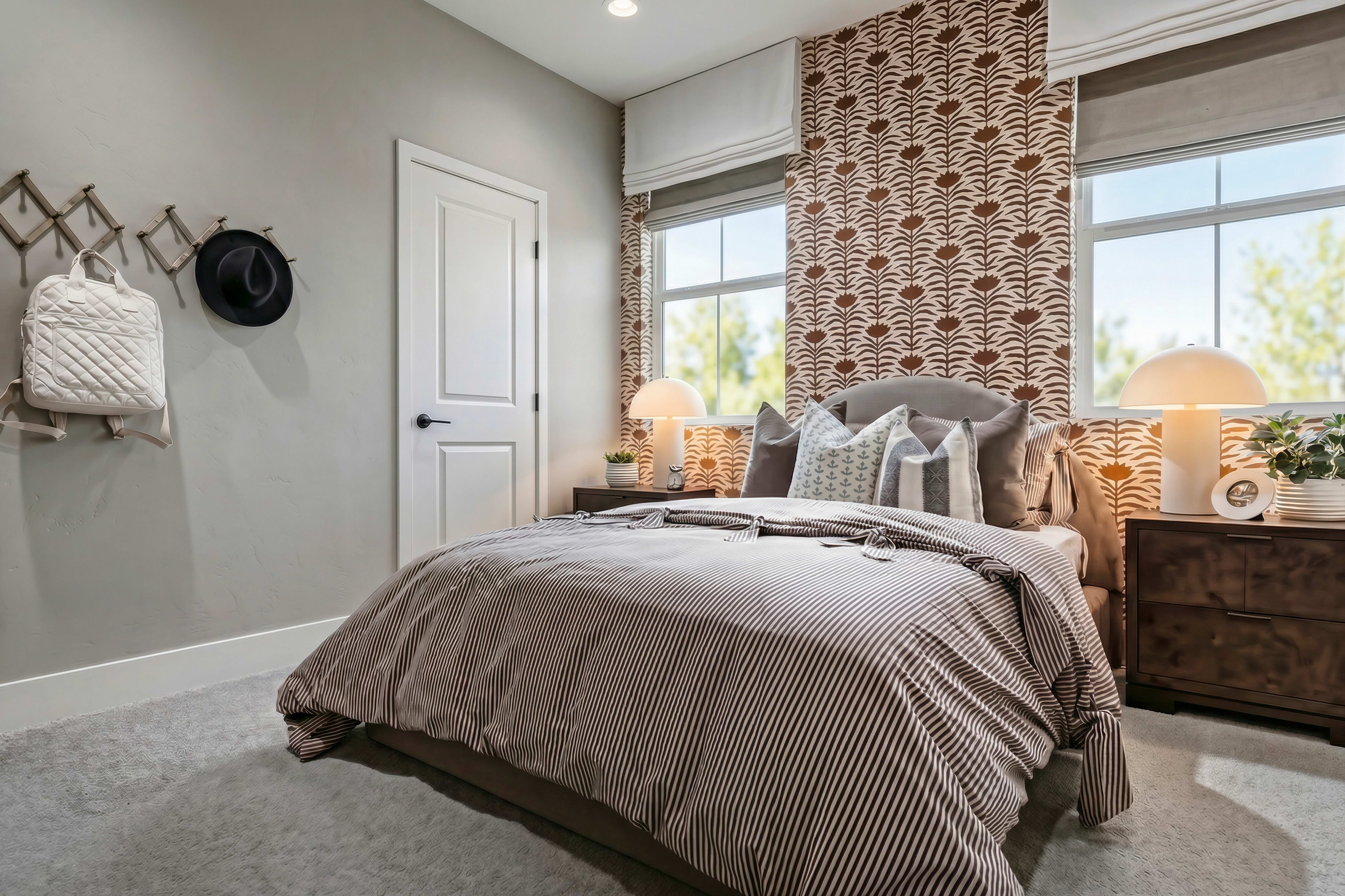 A cozy and inviting bedroom with a plush bedding set, patterned curtains, and decorative wall hangings, creating a warm and comfortable atmosphere.