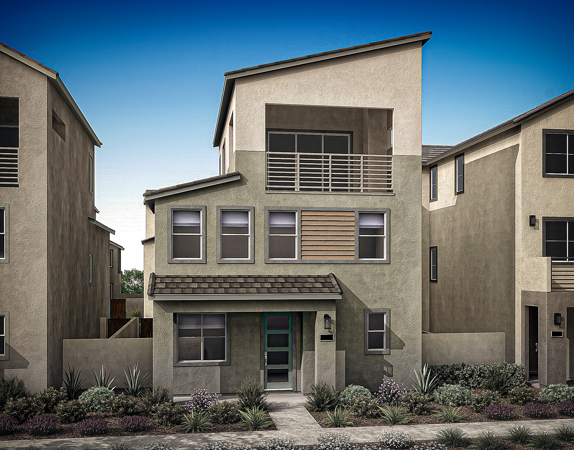 A modern, multi-story residential building with a gray exterior, featuring a balcony and various architectural elements, set against a clear blue sky.