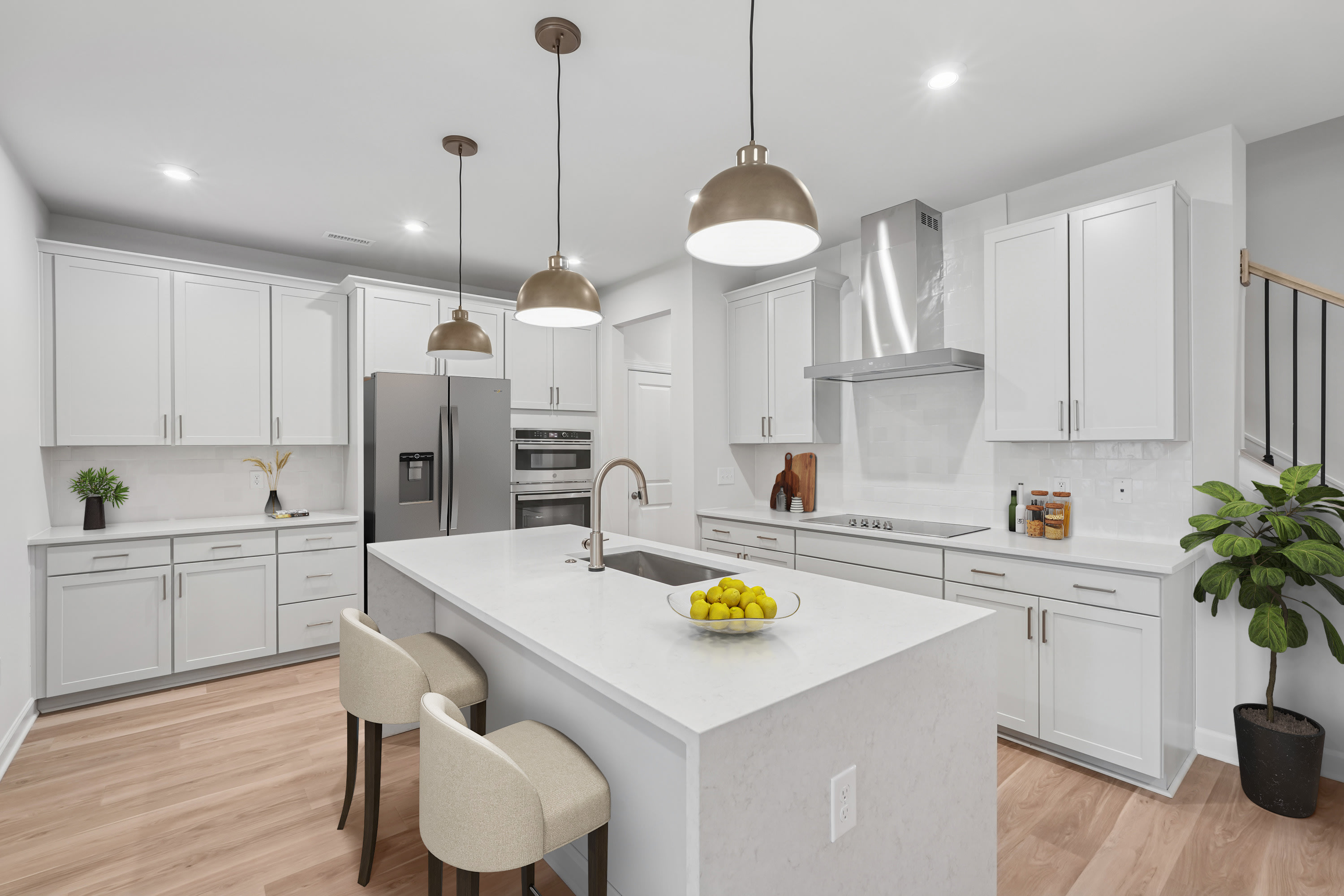A modern, well-lit kitchen with white cabinets, a large island with a white countertop, and pendant lights hanging above the island.