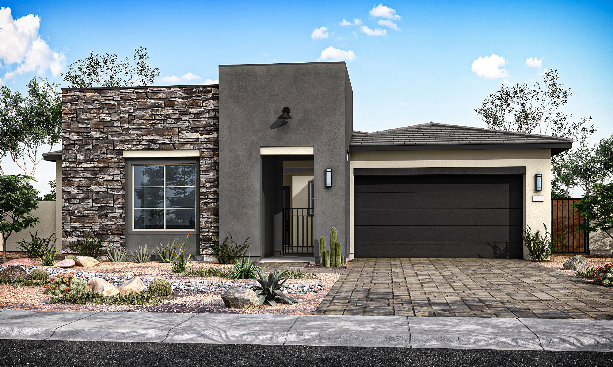 A modern stucco and stone house with a dark garage door sits on a paved driveway, with desert landscaping in the foreground and a bright blue sky with scattered clouds in the background.