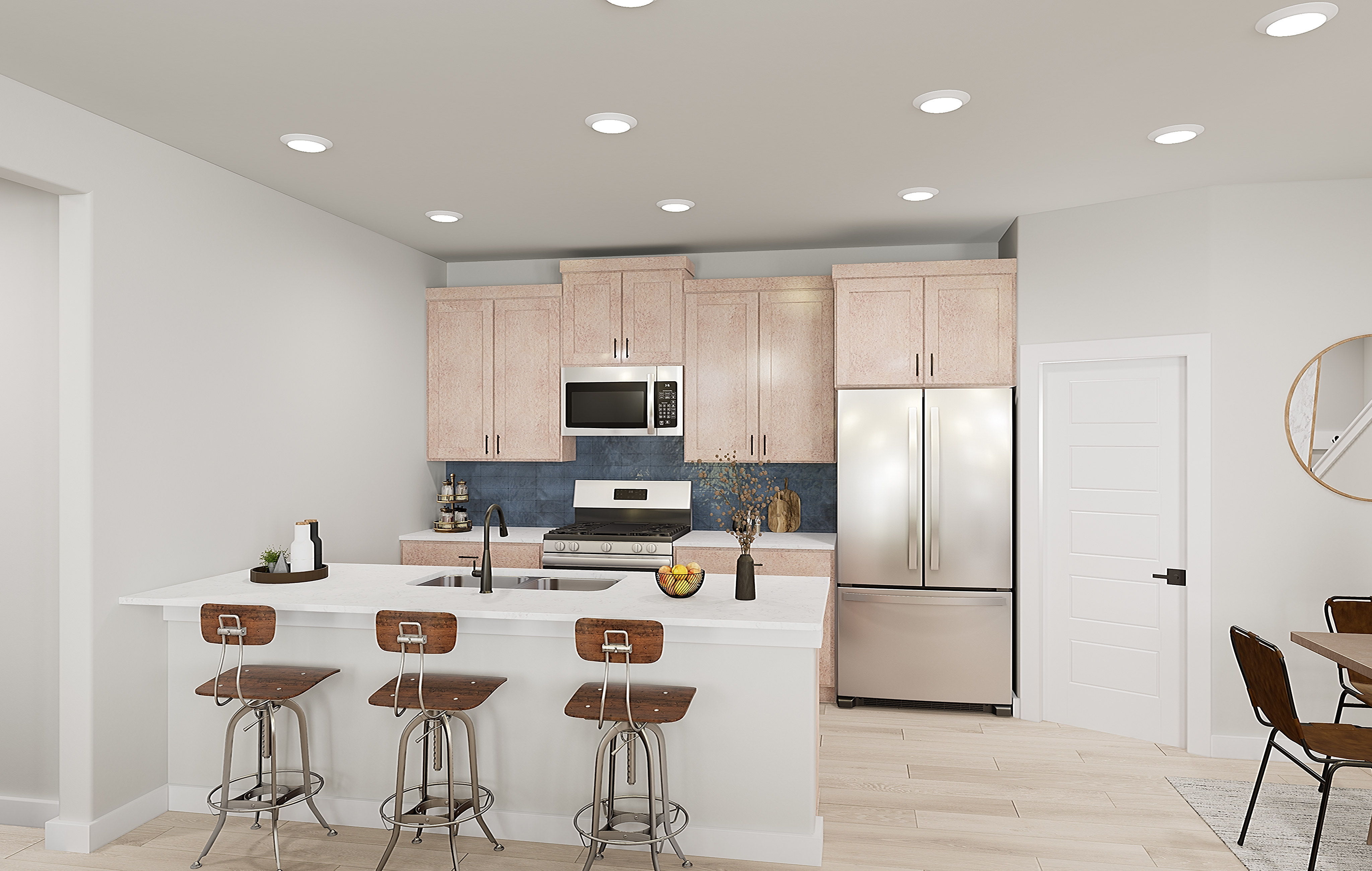 A modern kitchen with a white island and bar stools in the foreground is complemented by light wood cabinets, stainless steel appliances, and a dining area in the background.