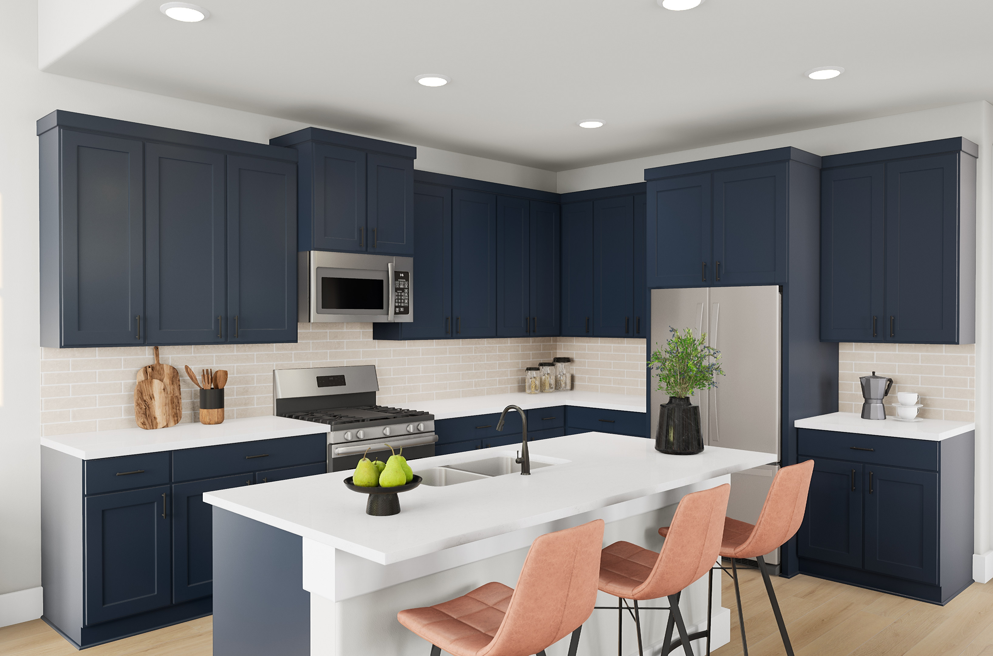 A modern kitchen with dark blue cabinets and a white island with coral bar stools in the foreground, and stainless steel appliances and a tiled backsplash in the background.