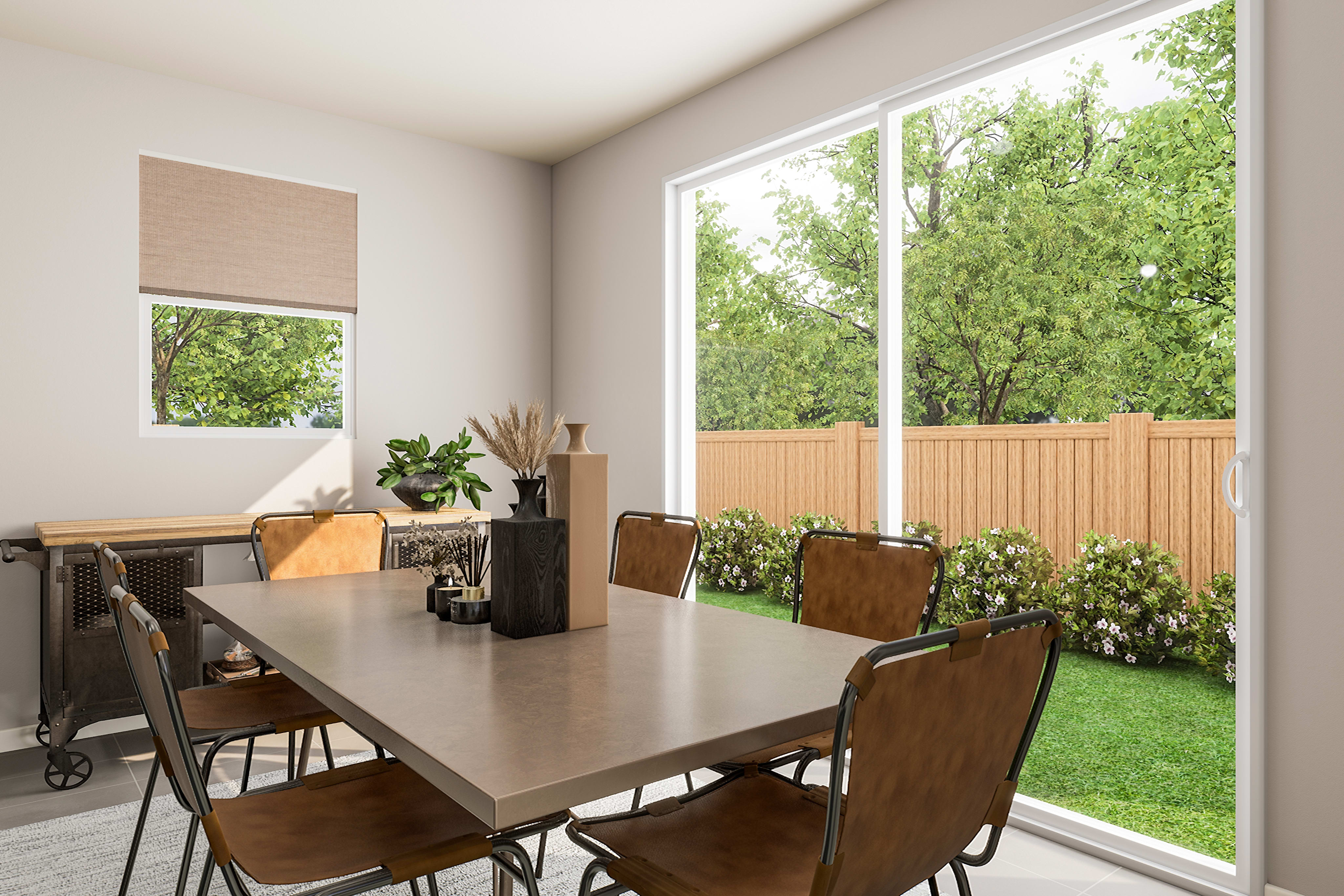 A dining table with chairs sits in the foreground, while a lush green backyard with a wooden fence is visible through a large sliding glass door in the background.