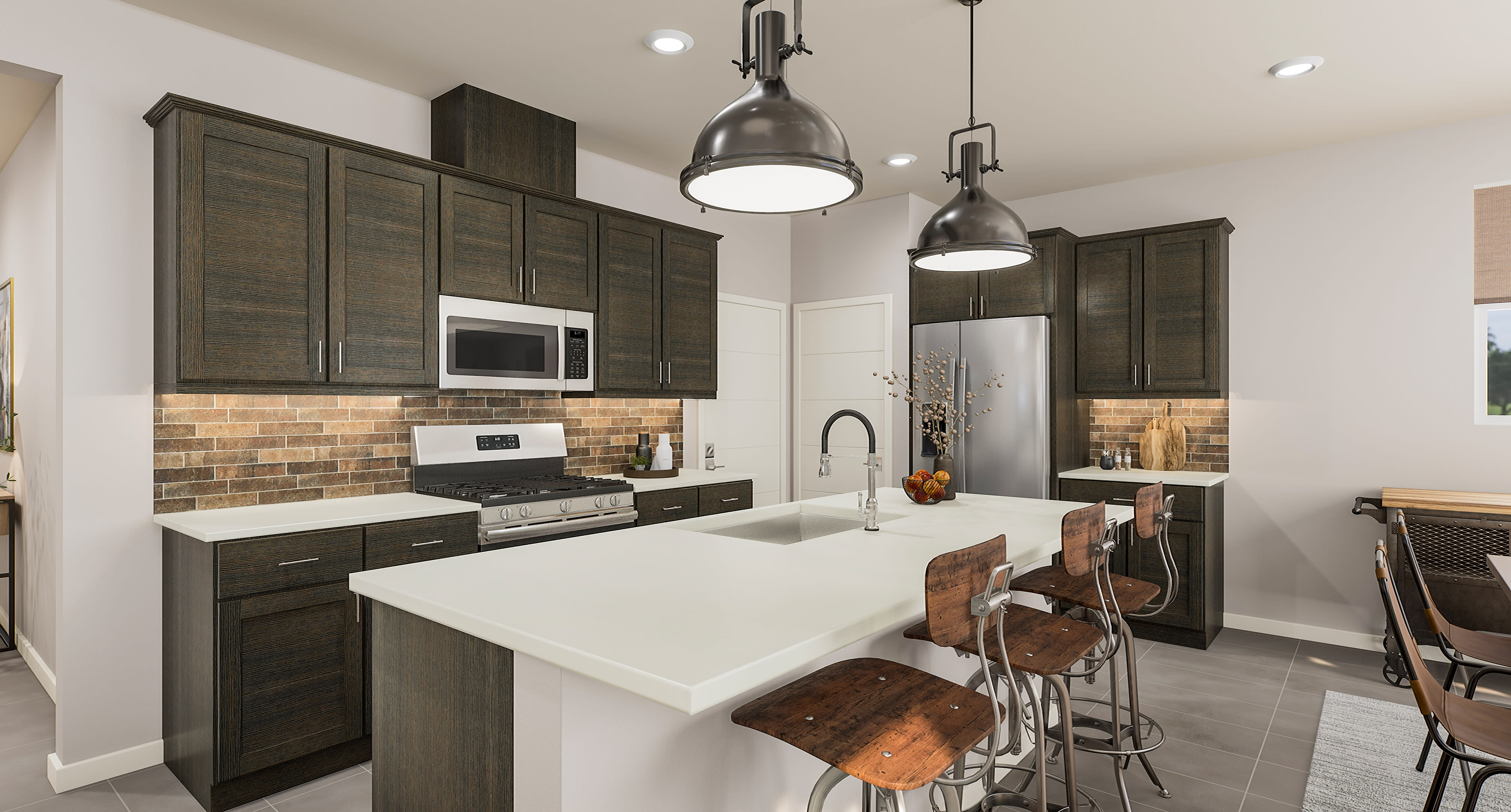 A modern kitchen with a large island and bar stools in the foreground, and stainless steel appliances and dark cabinetry in the background.