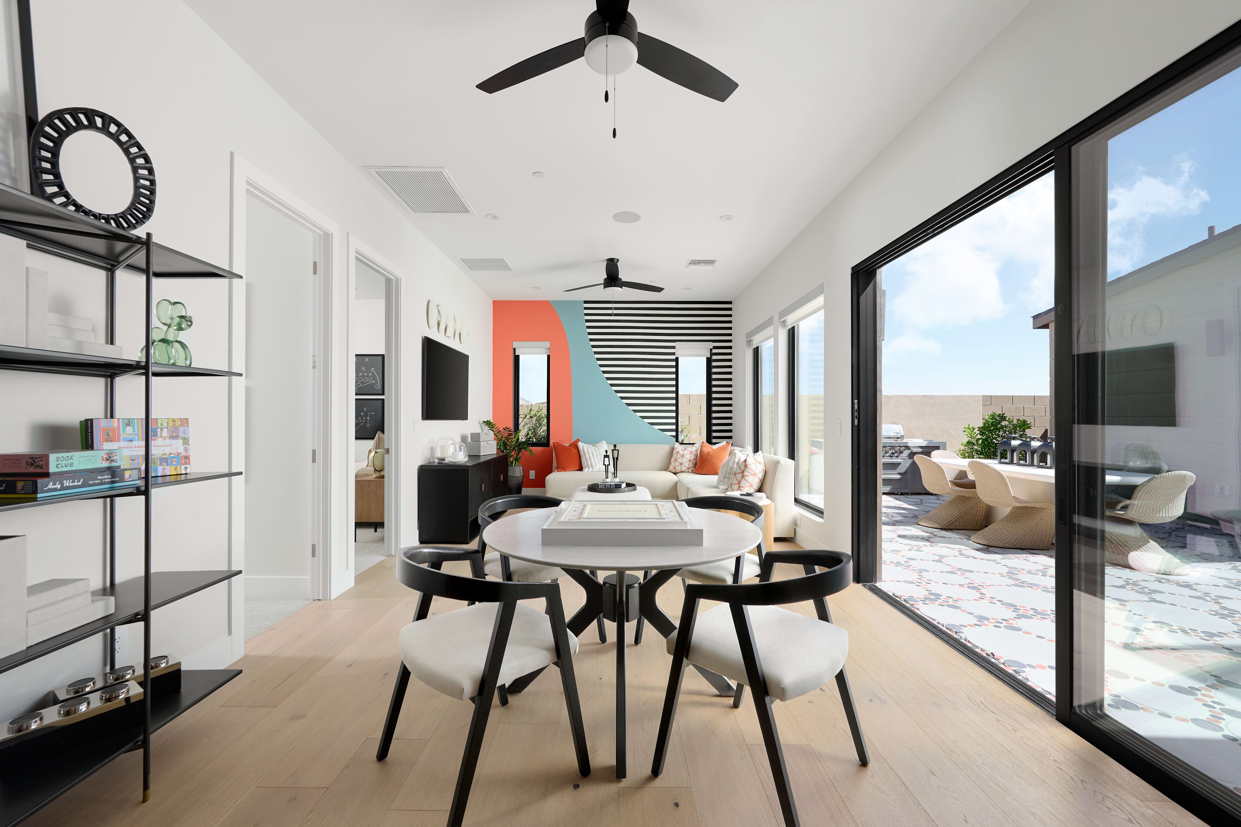 A modern and minimalist living space with a dining area, featuring a white and black color scheme, sleek furniture, and large windows providing natural light.