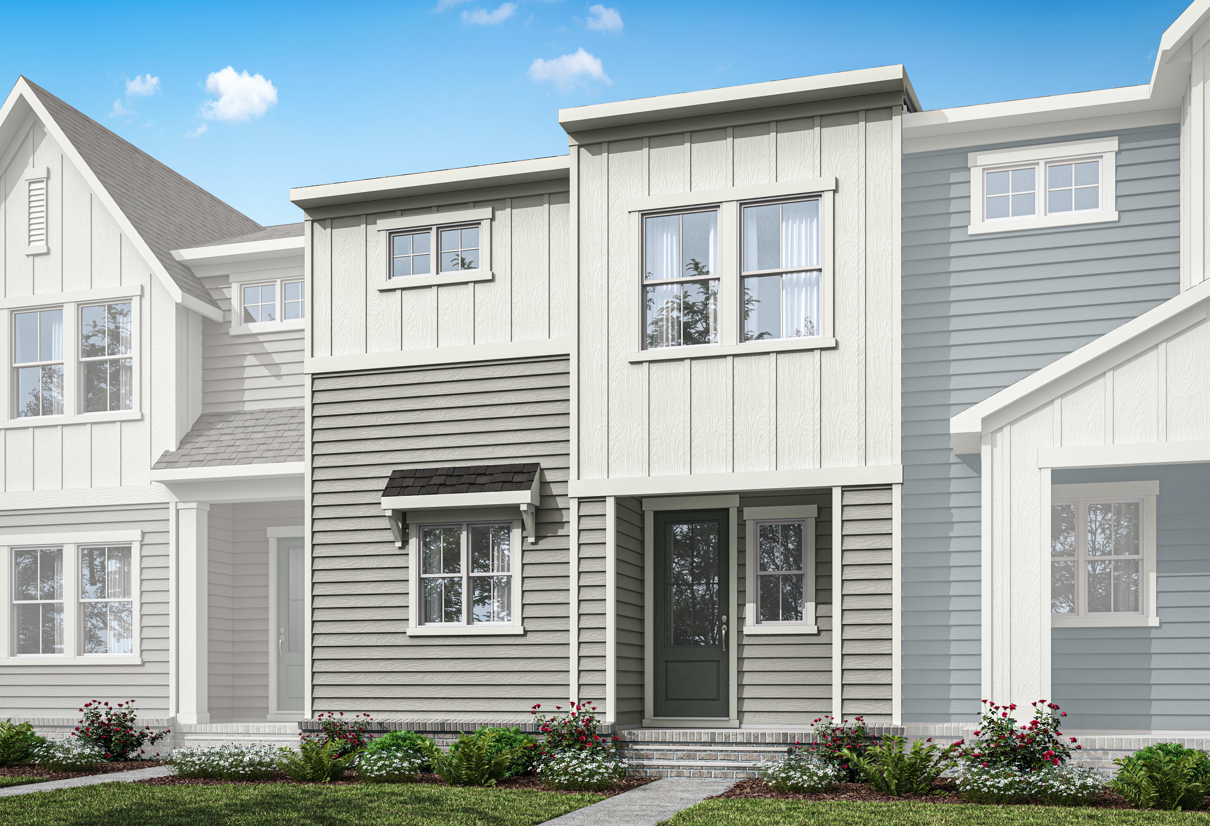 A modern, two-story townhouse with gray siding, white trim, and a covered entryway, set against a clear blue sky with fluffy white clouds.