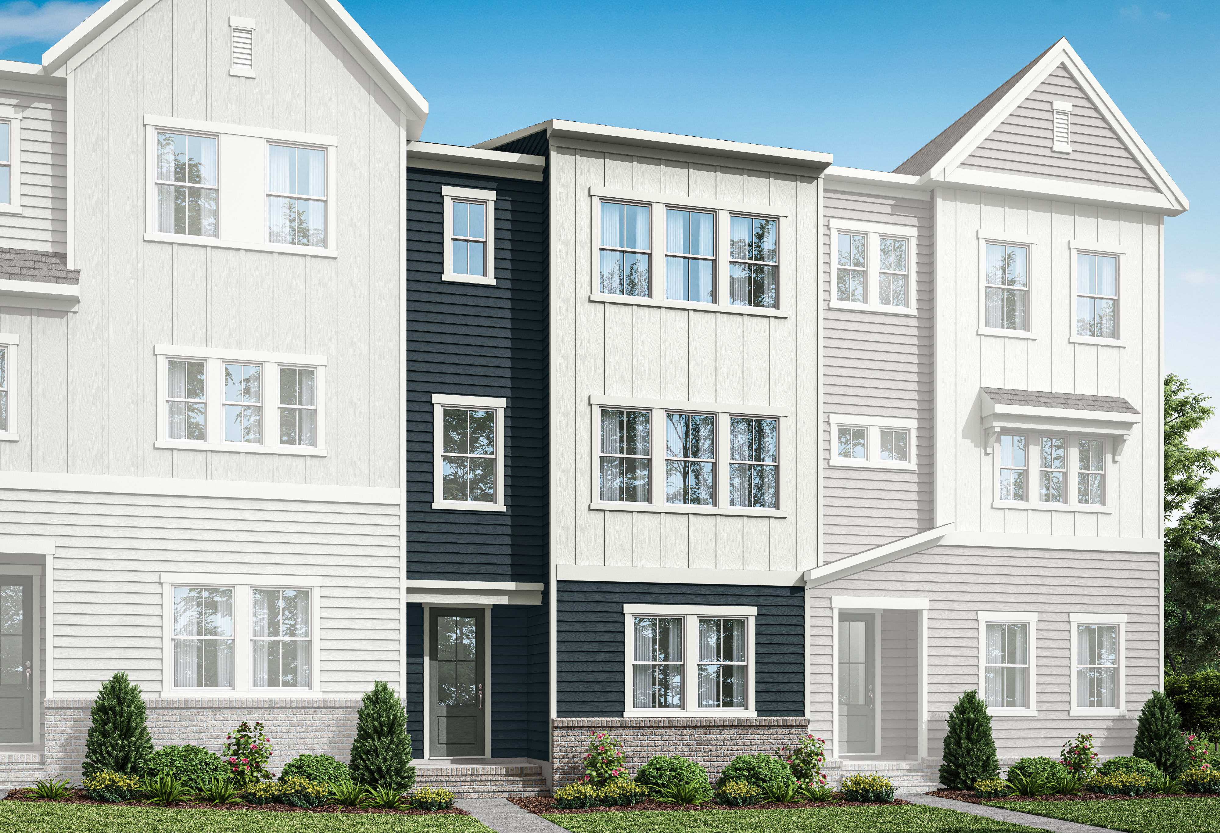 A multi-story residential building with a mix of white and dark gray siding, surrounded by a well-manicured lawn and landscaping.