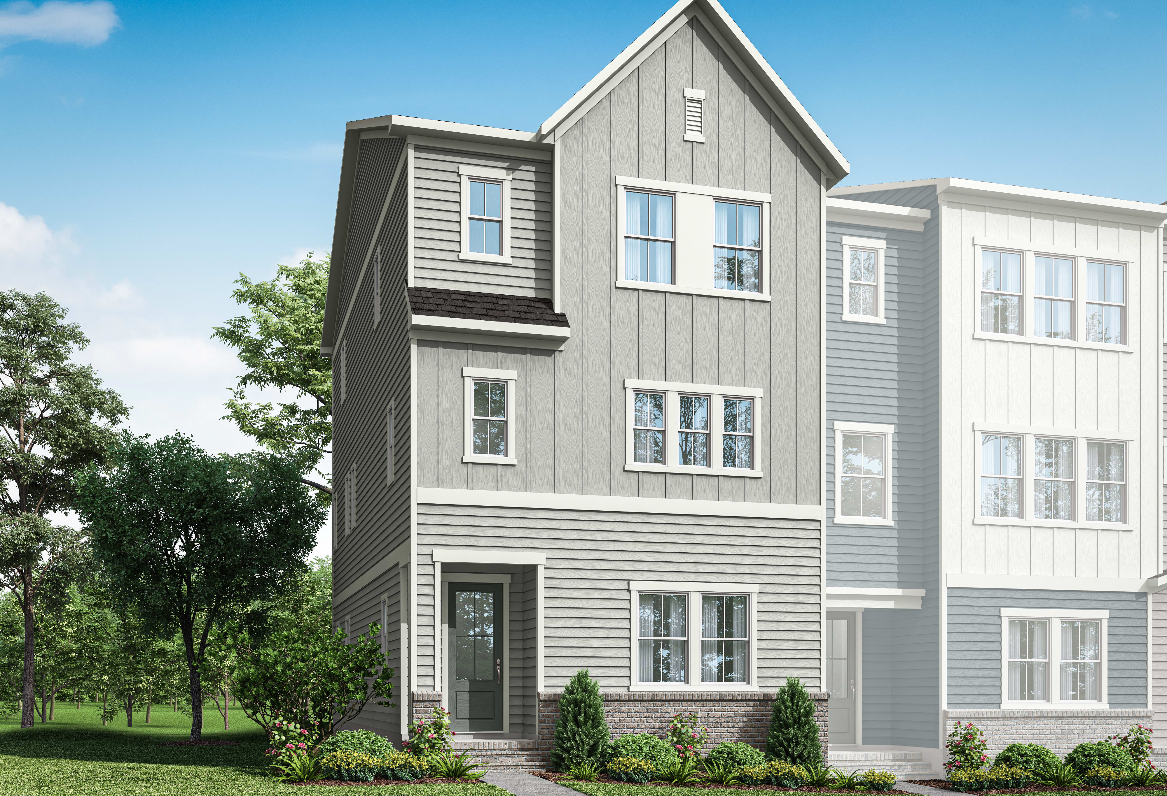 A modern, multi-story residential building with gray siding and white trim, surrounded by lush greenery and a clear blue sky.