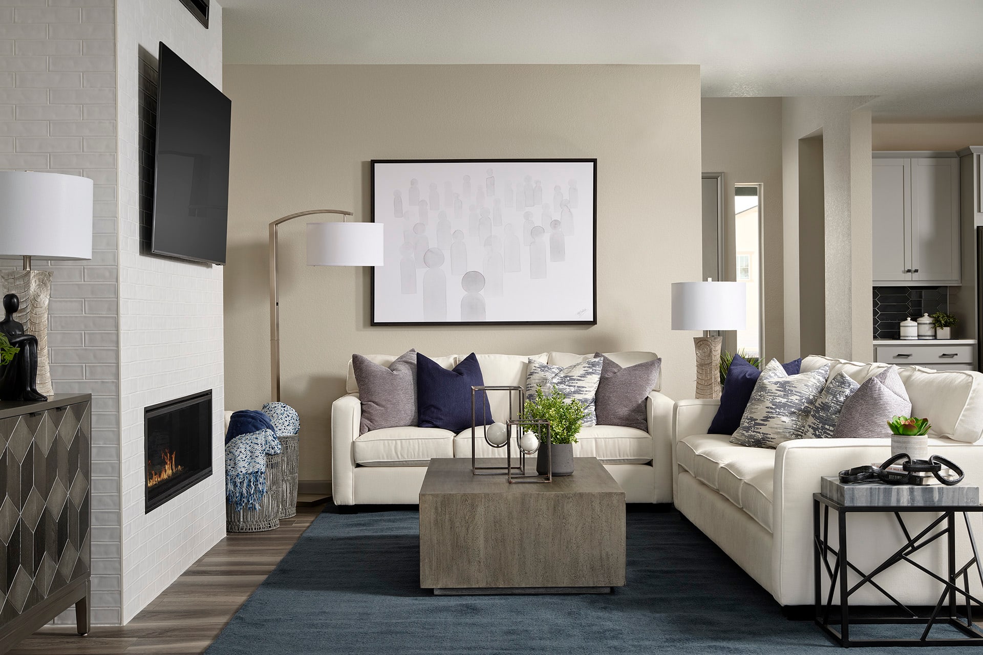 A cozy and modern living room with a fireplace, neutral-colored furniture, and decorative accents creating a warm and inviting atmosphere.