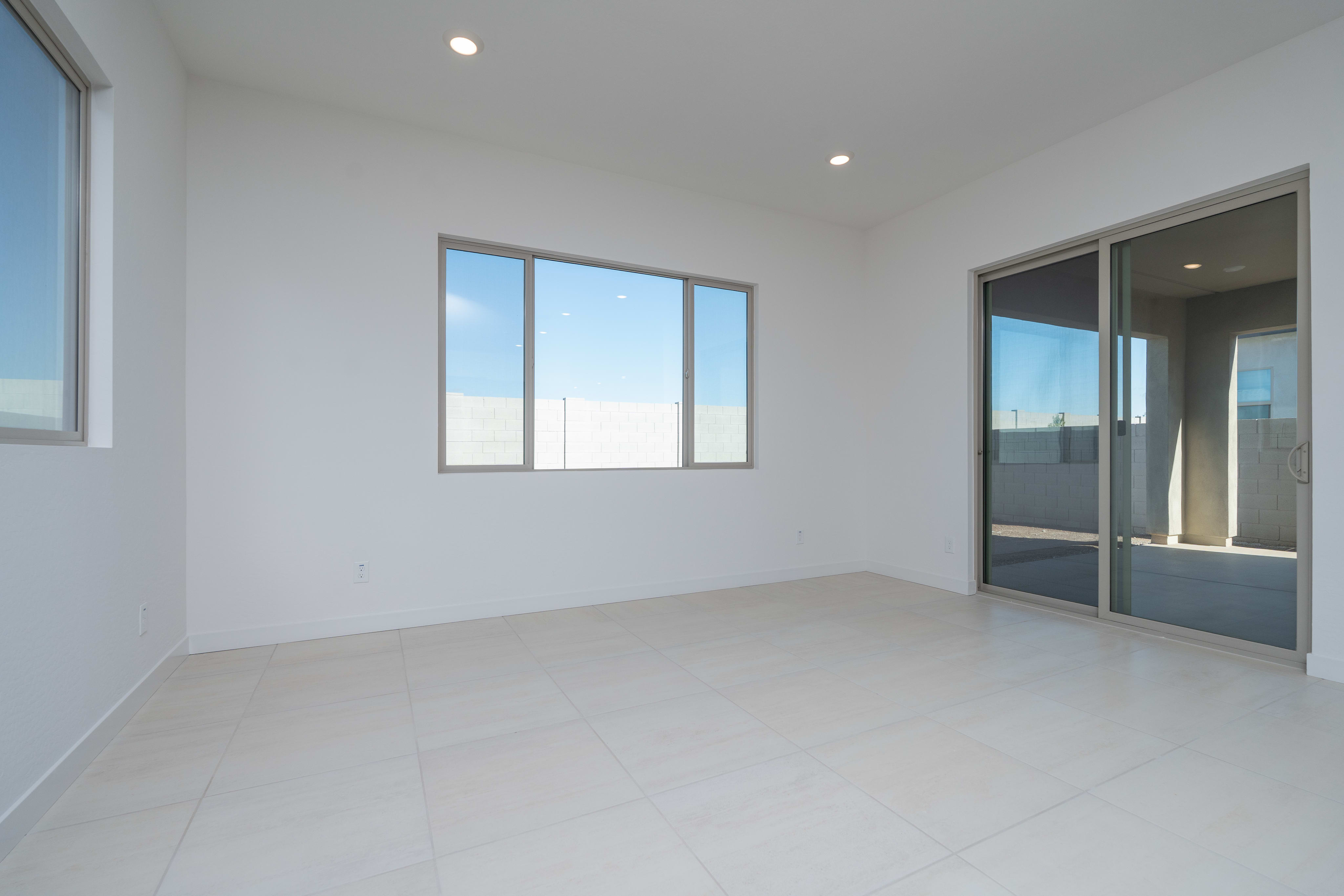 A bright, minimalist room with large windows overlooking an outdoor area.