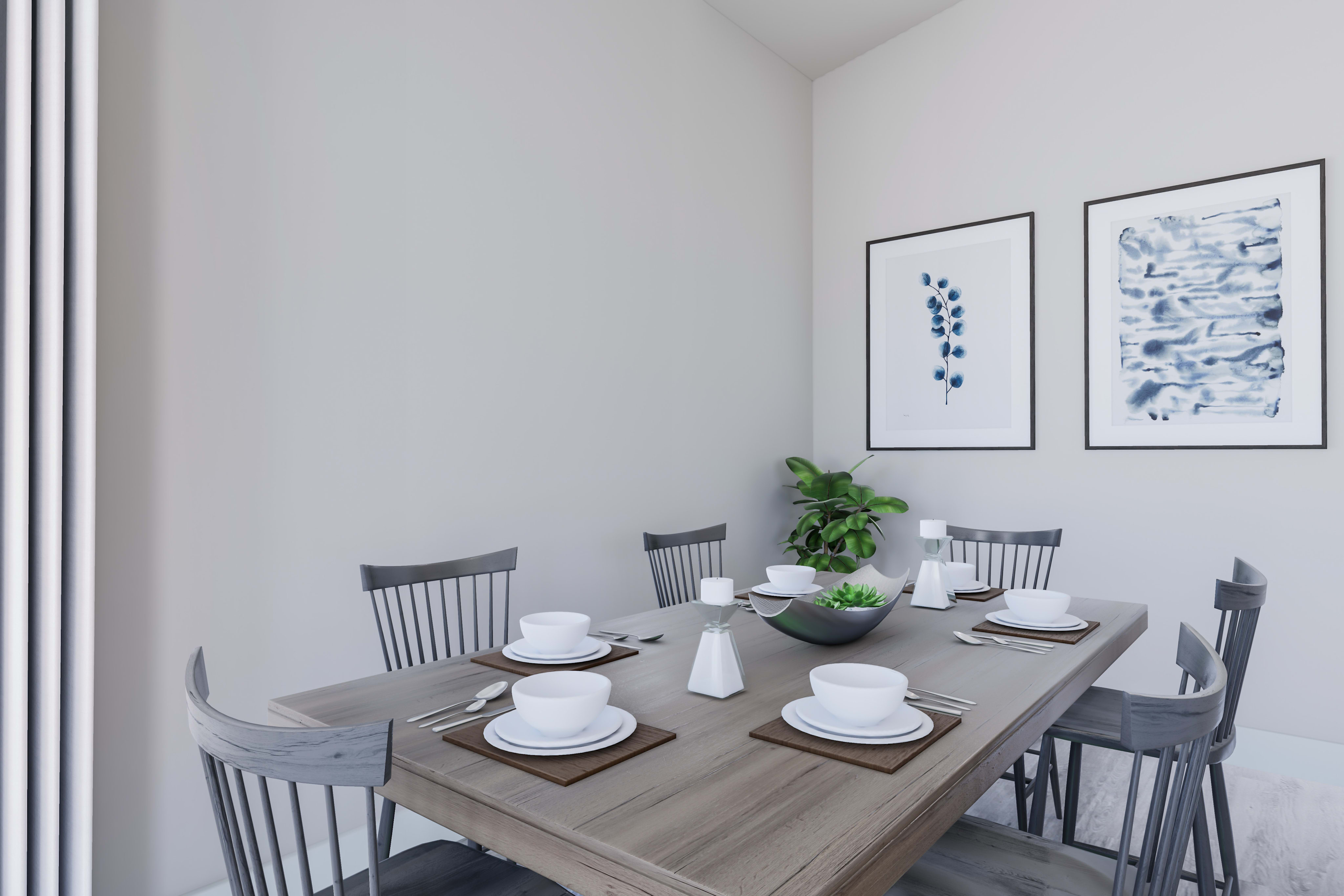 A minimalist dining area with a wooden table, gray chairs, and framed artwork on the walls, creating a clean and modern aesthetic.