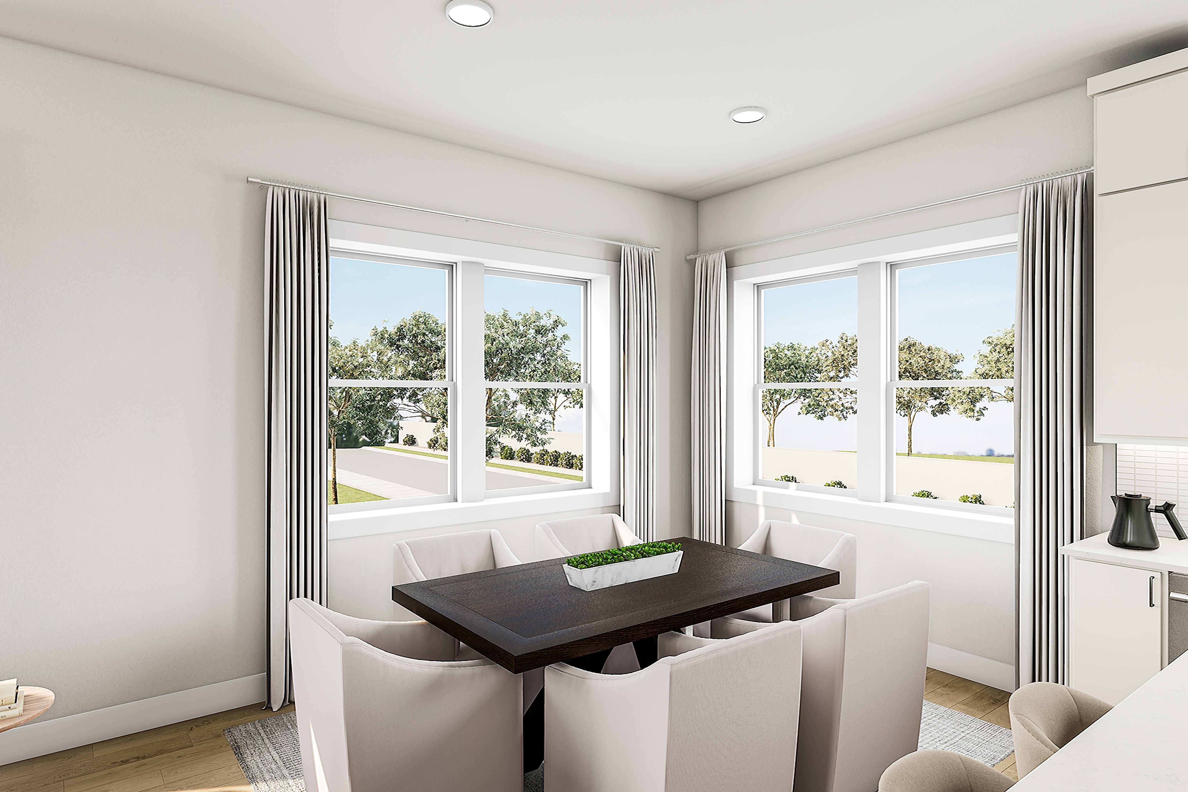 A bright and airy dining area with large windows overlooking a lush outdoor landscape, featuring a wooden table and cushioned benches.