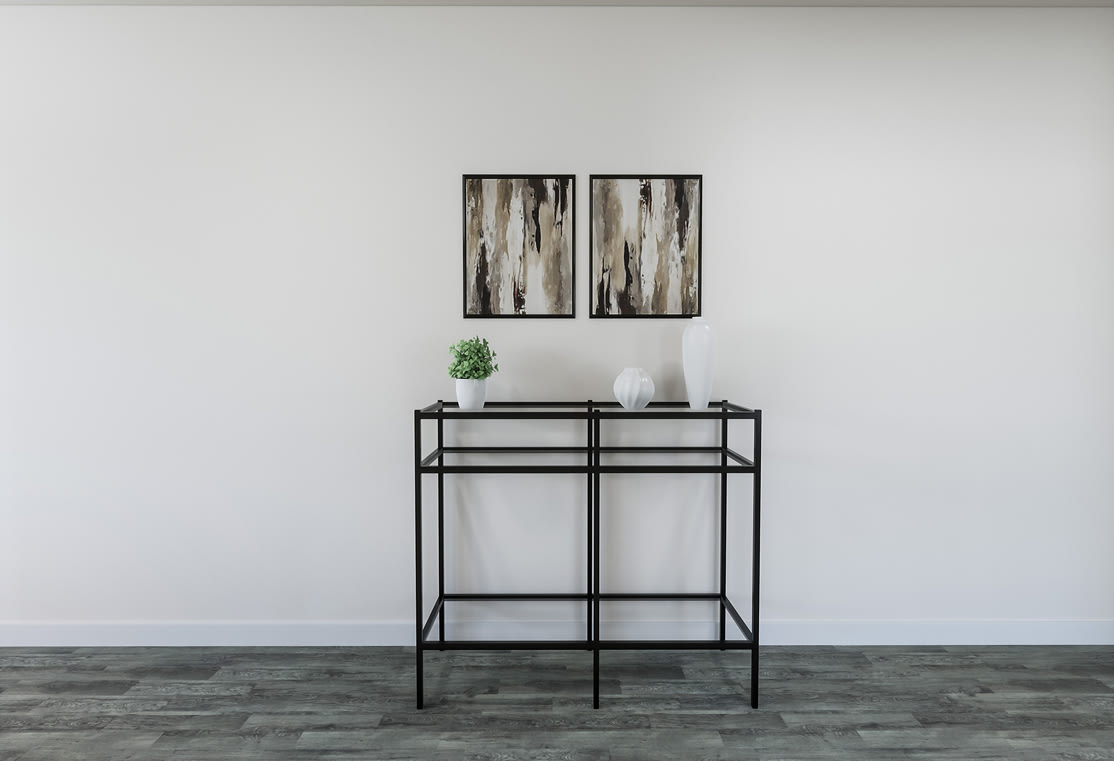 A minimalist, modern interior with a black metal shelving unit displaying decorative items against a plain white wall.