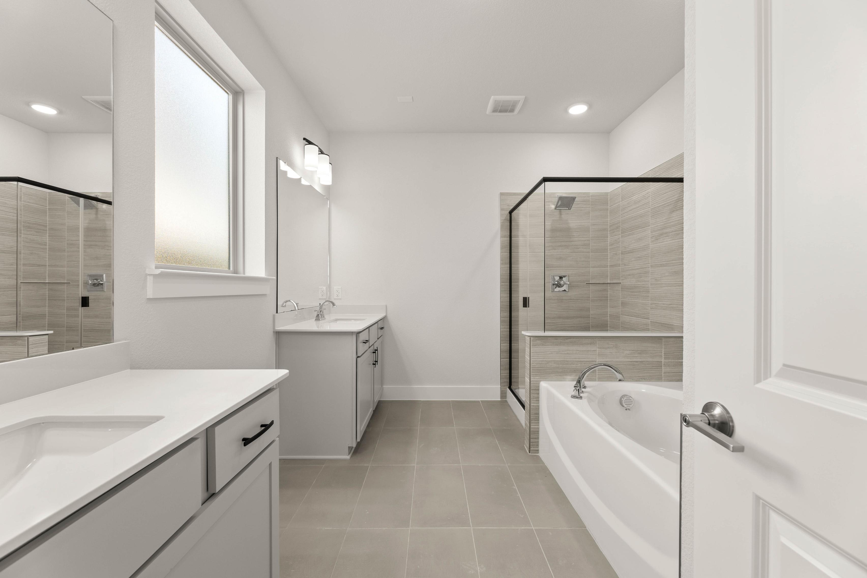 A modern, minimalist bathroom with a white vanity, a freestanding bathtub, and a large window providing natural light.