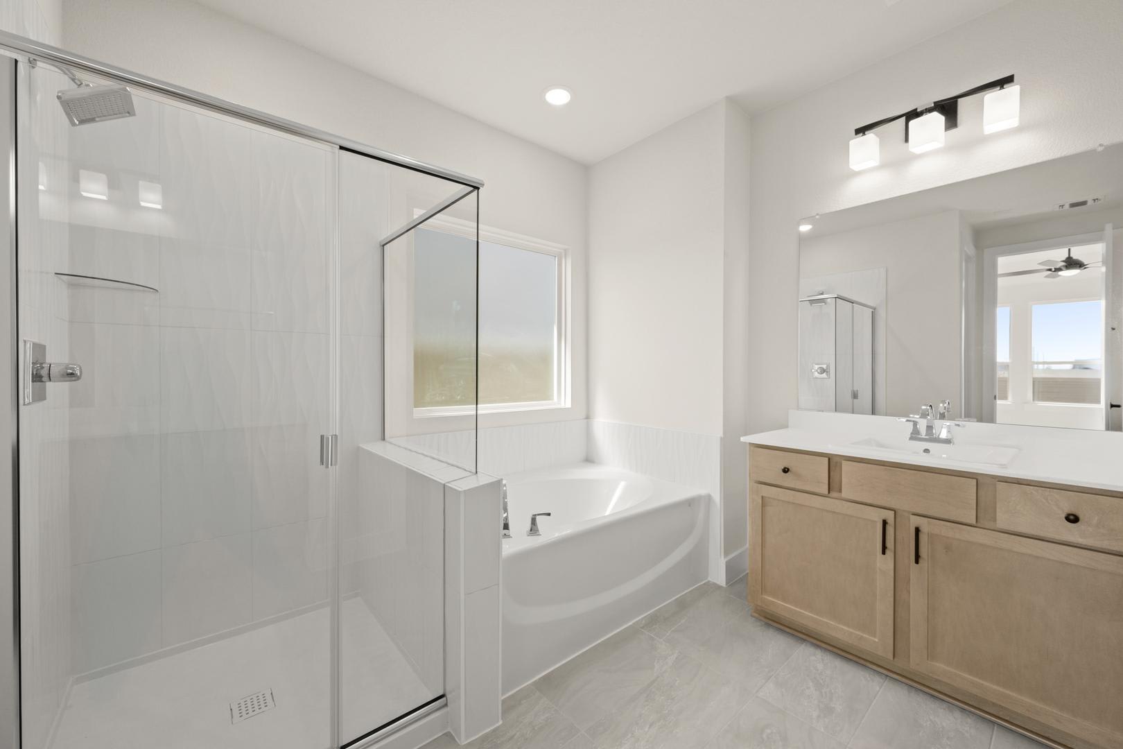 A modern, minimalist bathroom with a white tiled floor, a large mirror, and a wooden vanity with a white countertop.