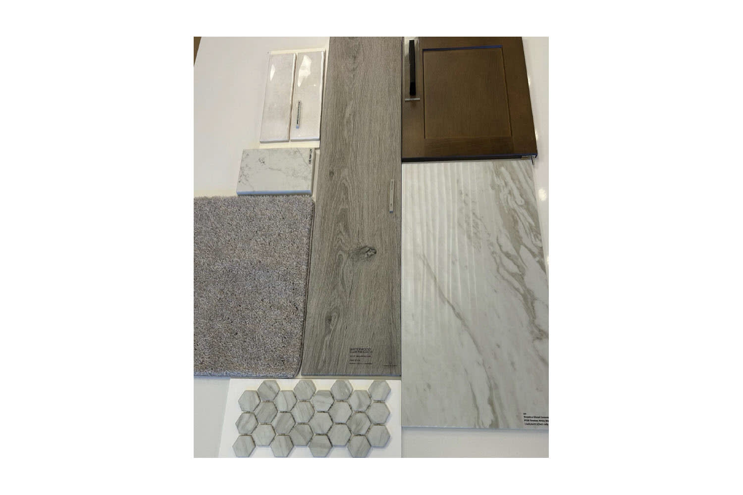 The image shows a close-up view of a bathroom floor, featuring a combination of different materials and textures, including wood-like tiles, gray hexagonal tiles, and a granite-like countertop.