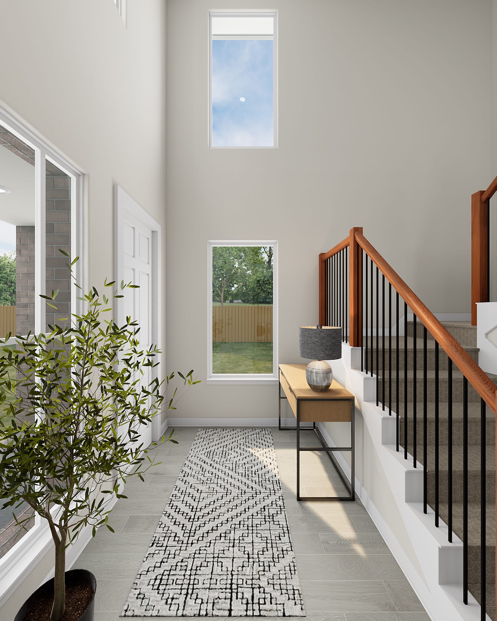 A spacious and modern entryway with a potted plant, a wooden bench, and a patterned rug leading to a staircase with a metal railing, all set against a backdrop of large windows and a view of the outdoors.