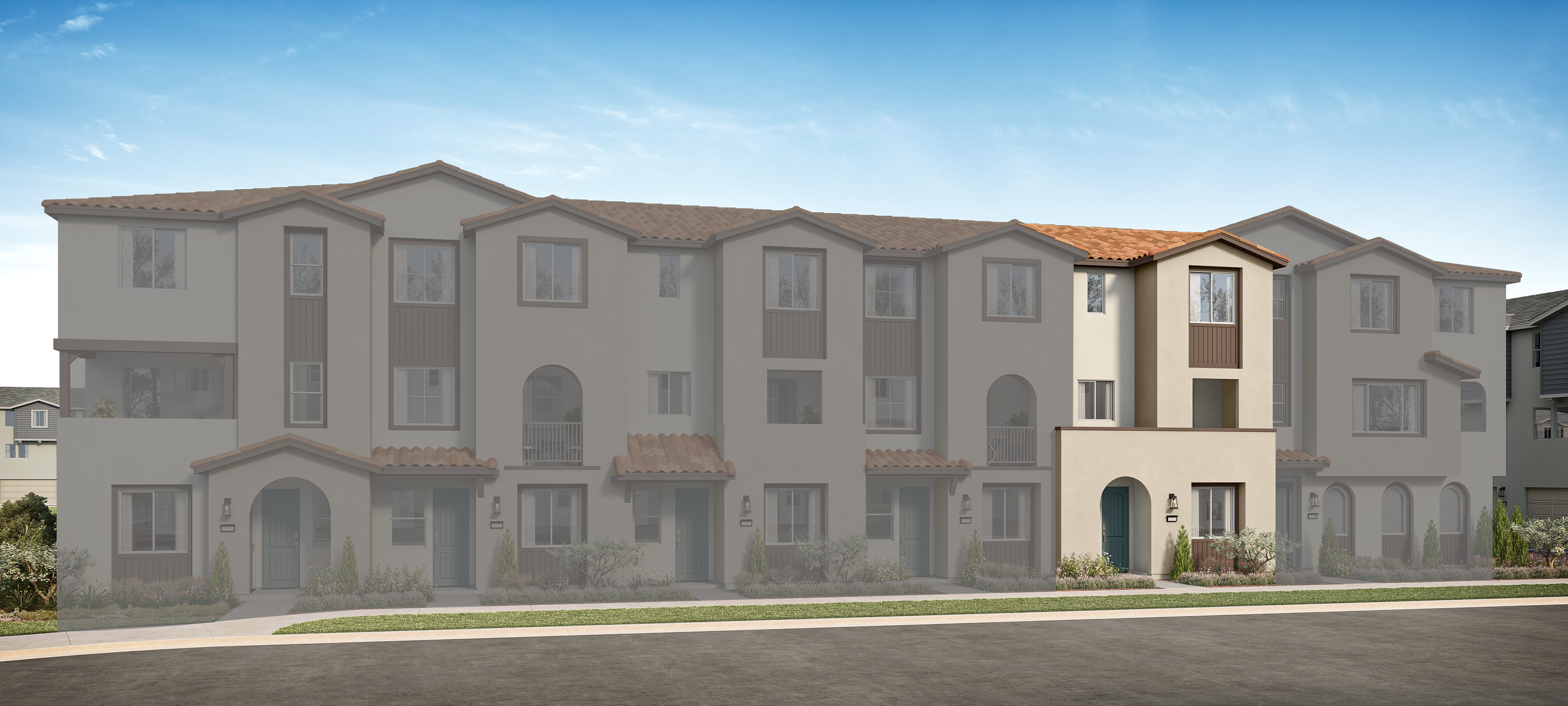 A row of multi-story, beige-colored townhouses with arched windows and decorative architectural features, set against a clear blue sky with a few wispy clouds.