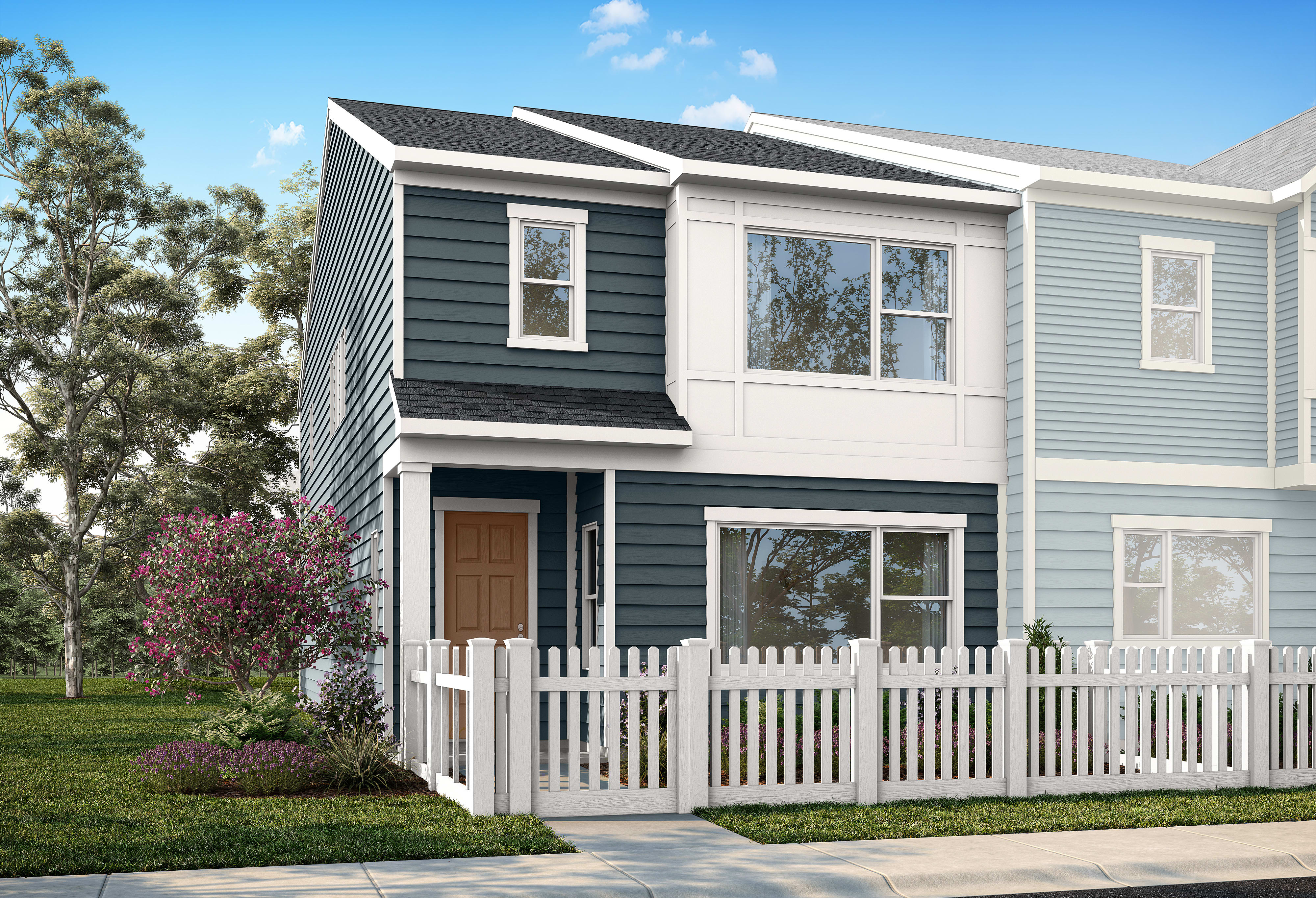 A modern townhouse with a white picket fence in the foreground is set against a backdrop of trees and a bright blue sky.