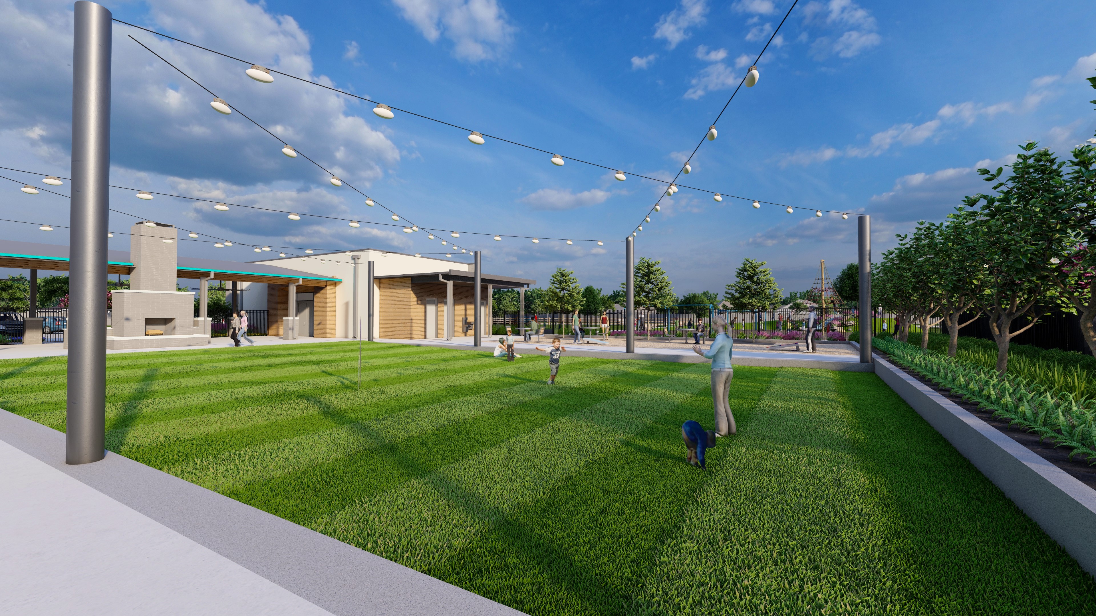 A well-manicured grassy area with string lights overhead, surrounded by trees and buildings, creating a pleasant outdoor gathering space.