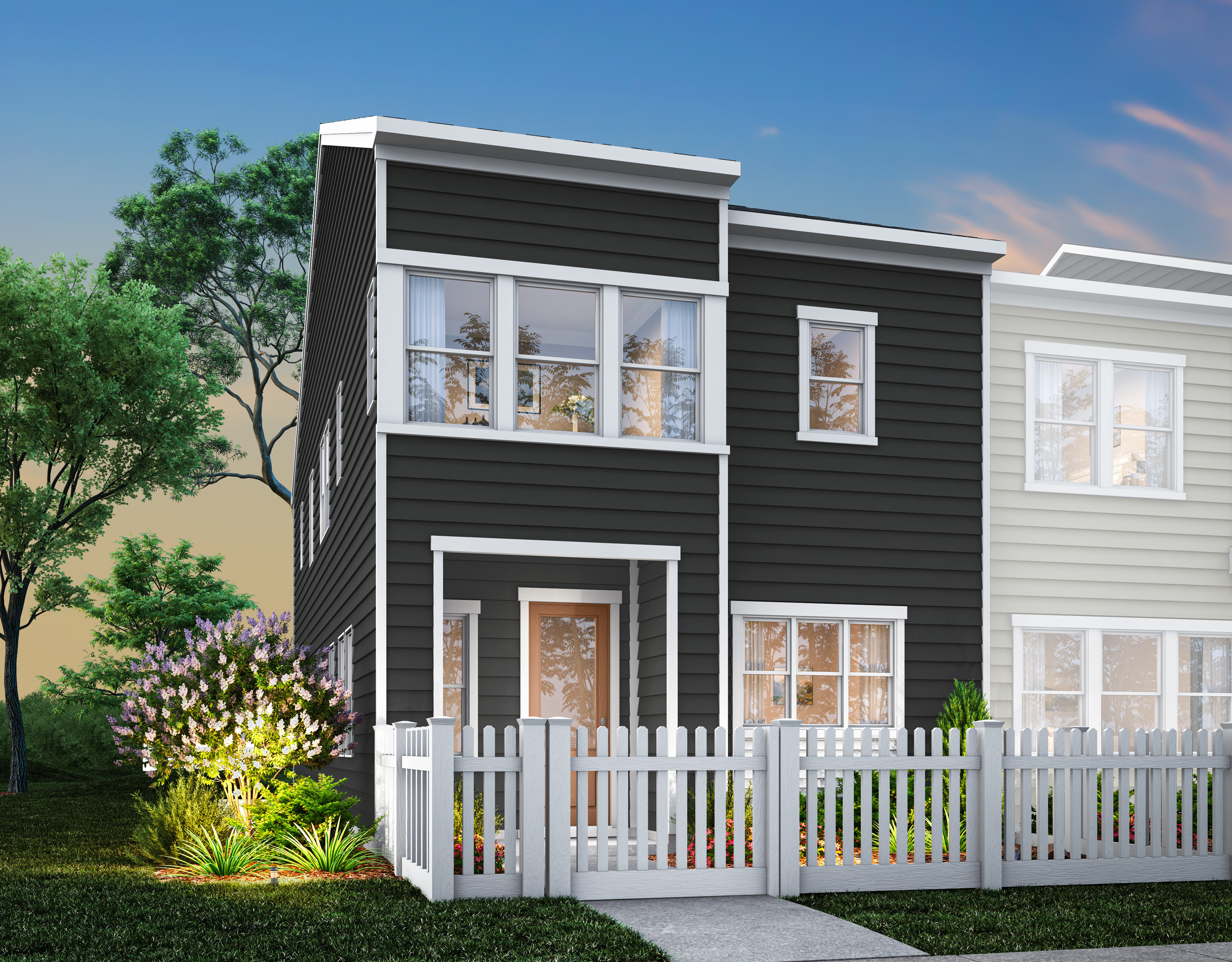 A modern two-story townhouse with a white picket fence and lush greenery in the foreground, set against a backdrop of a clear blue sky.