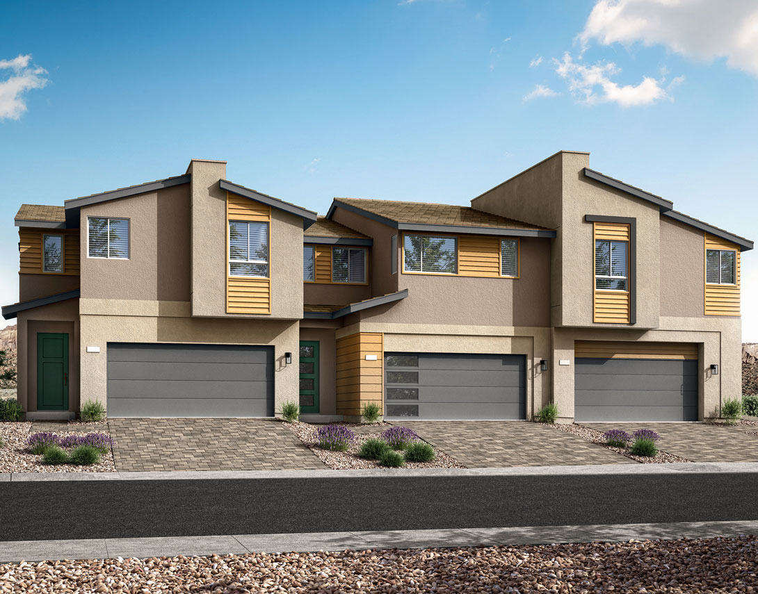 The image depicts a row of modern, two-story townhouses with beige and yellow exterior walls, gray garage doors, and a paved driveway in the foreground. The background features a clear blue sky with scattered clouds.