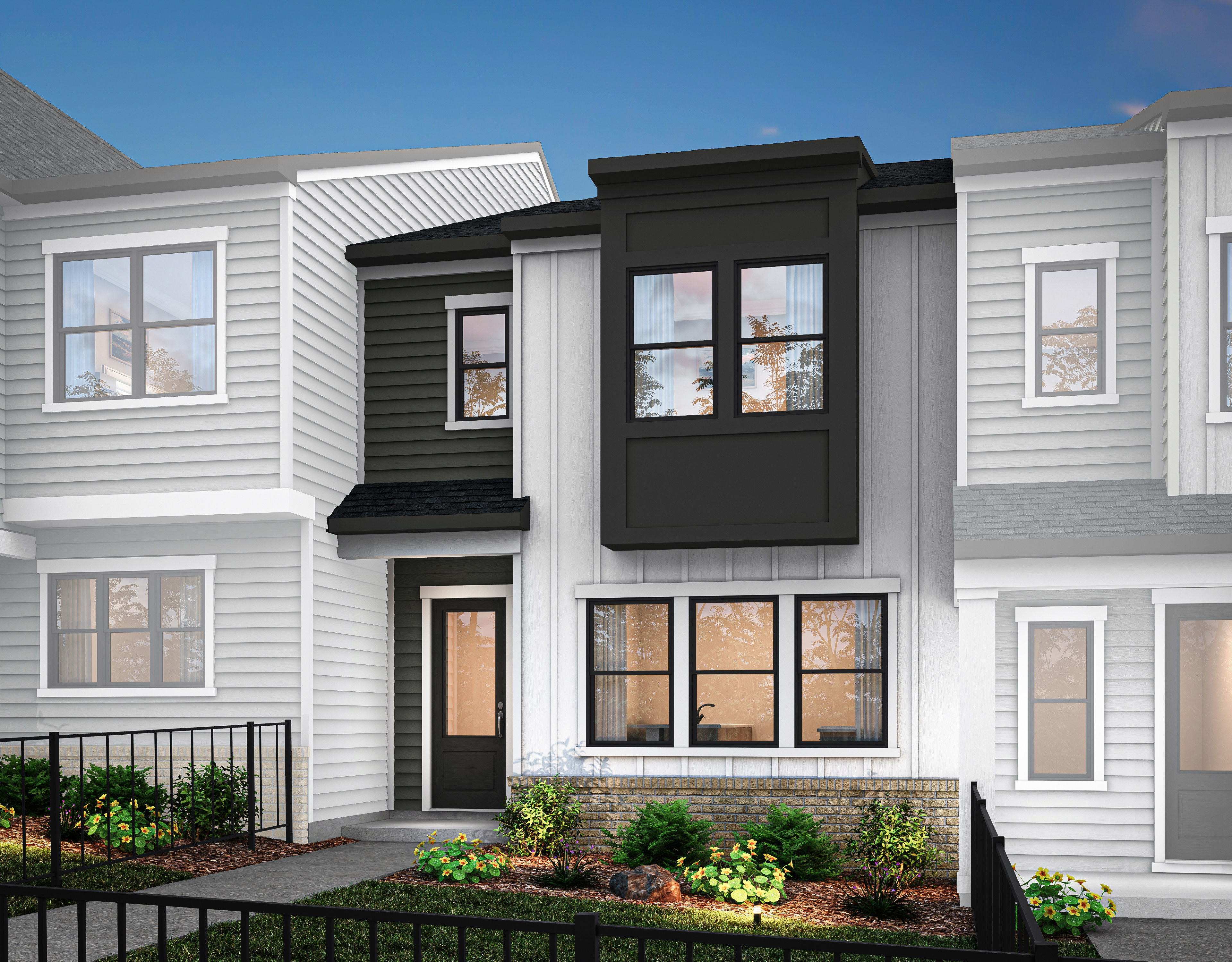 A modern townhouse with a white exterior, black trim, and a well-landscaped front yard featuring greenery and plants.