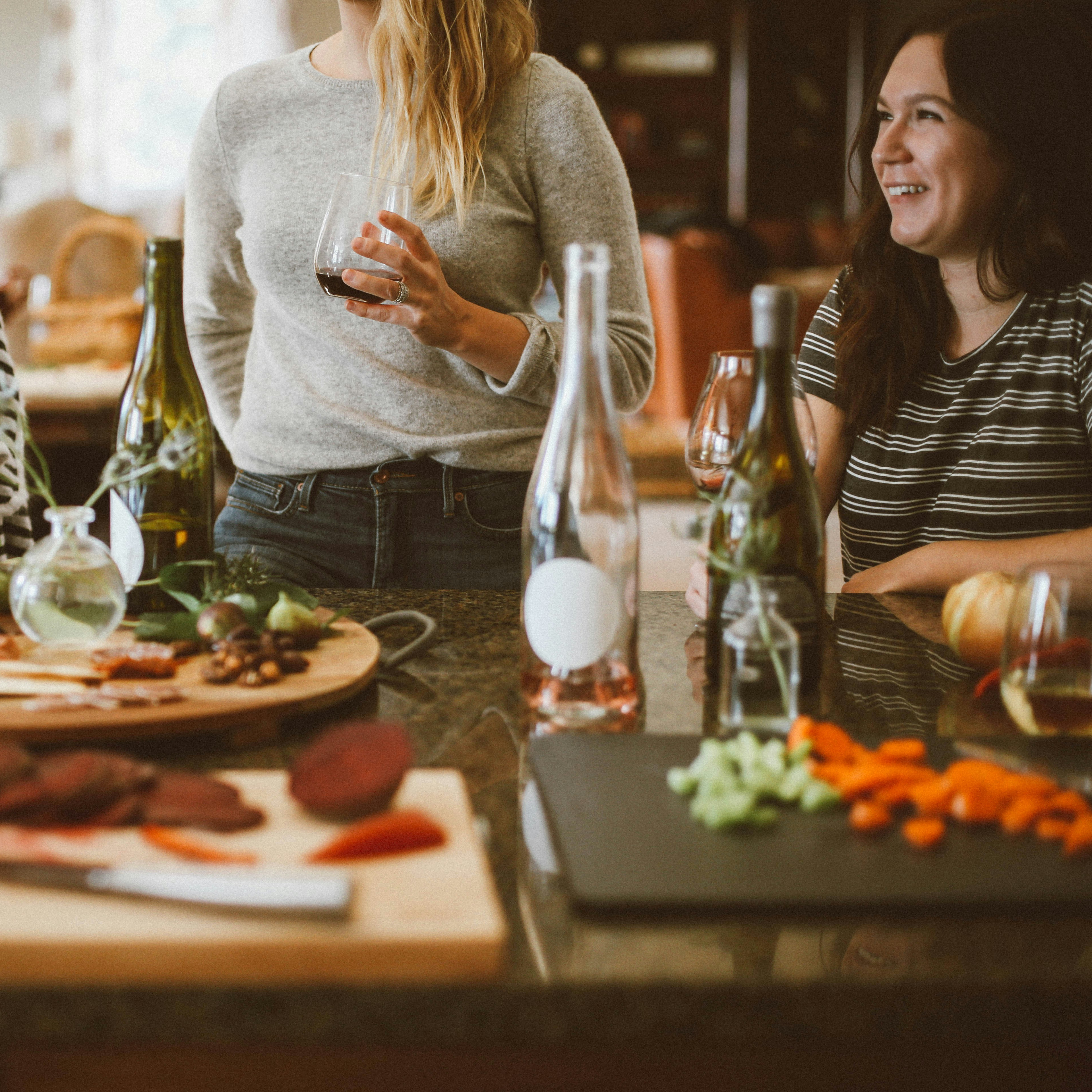 A cozy gathering of friends enjoying a meal together, with a table full of delectable dishes and drinks in a warm, inviting setting.