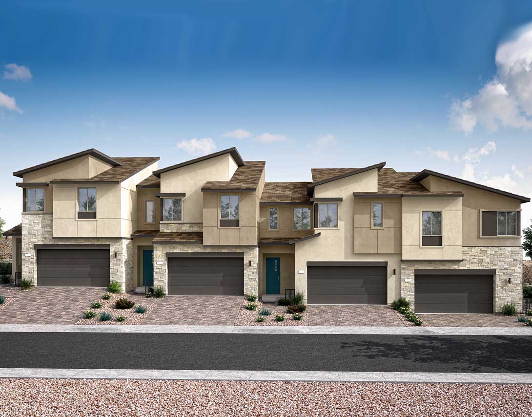 A row of modern, two-story townhouses with beige and stone exteriors, set against a clear blue sky with scattered clouds, and a paved driveway in the foreground.