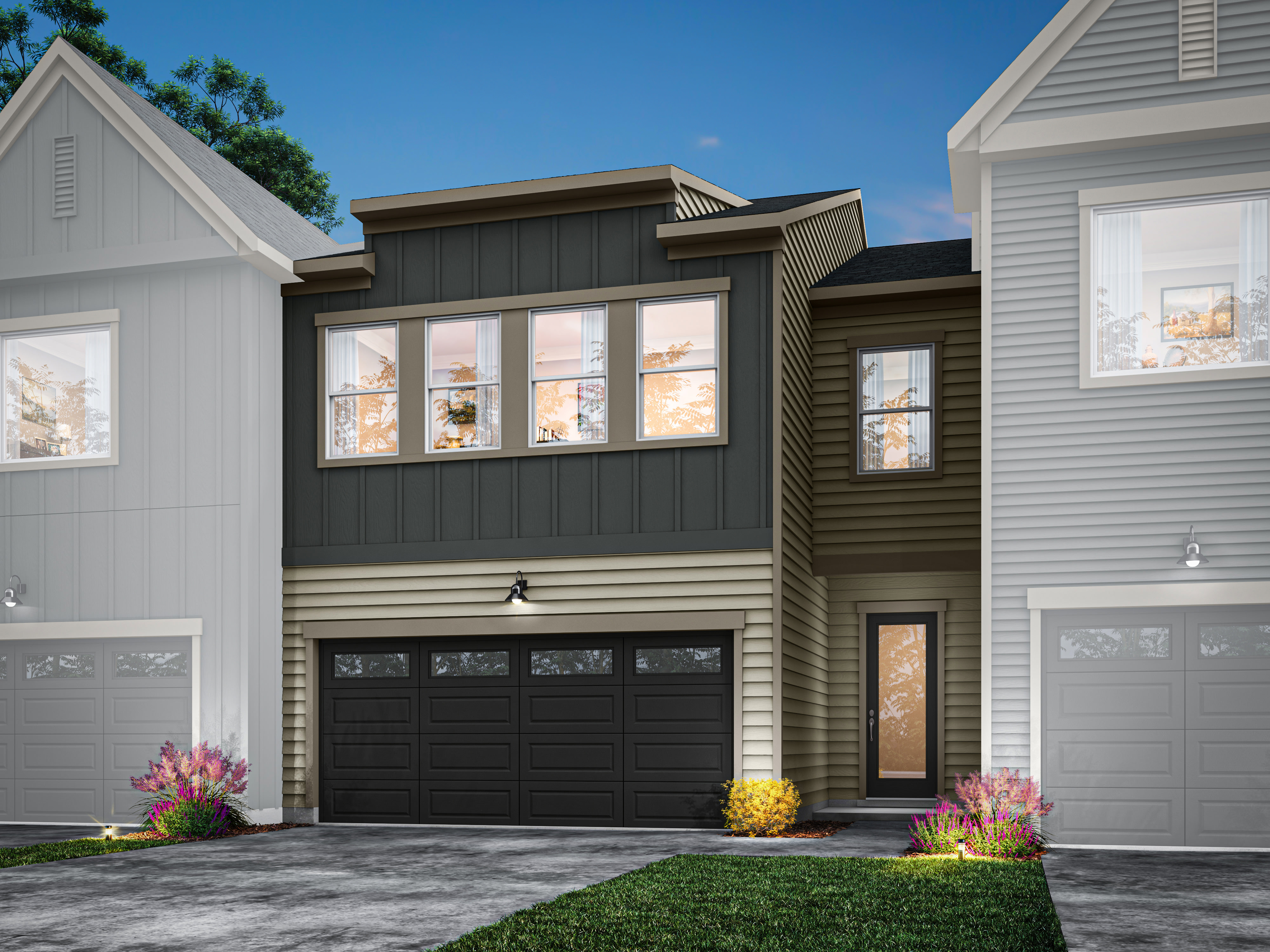 A modern two-story townhouse with a black garage door, large windows, and a landscaped front yard with colorful flowers.
