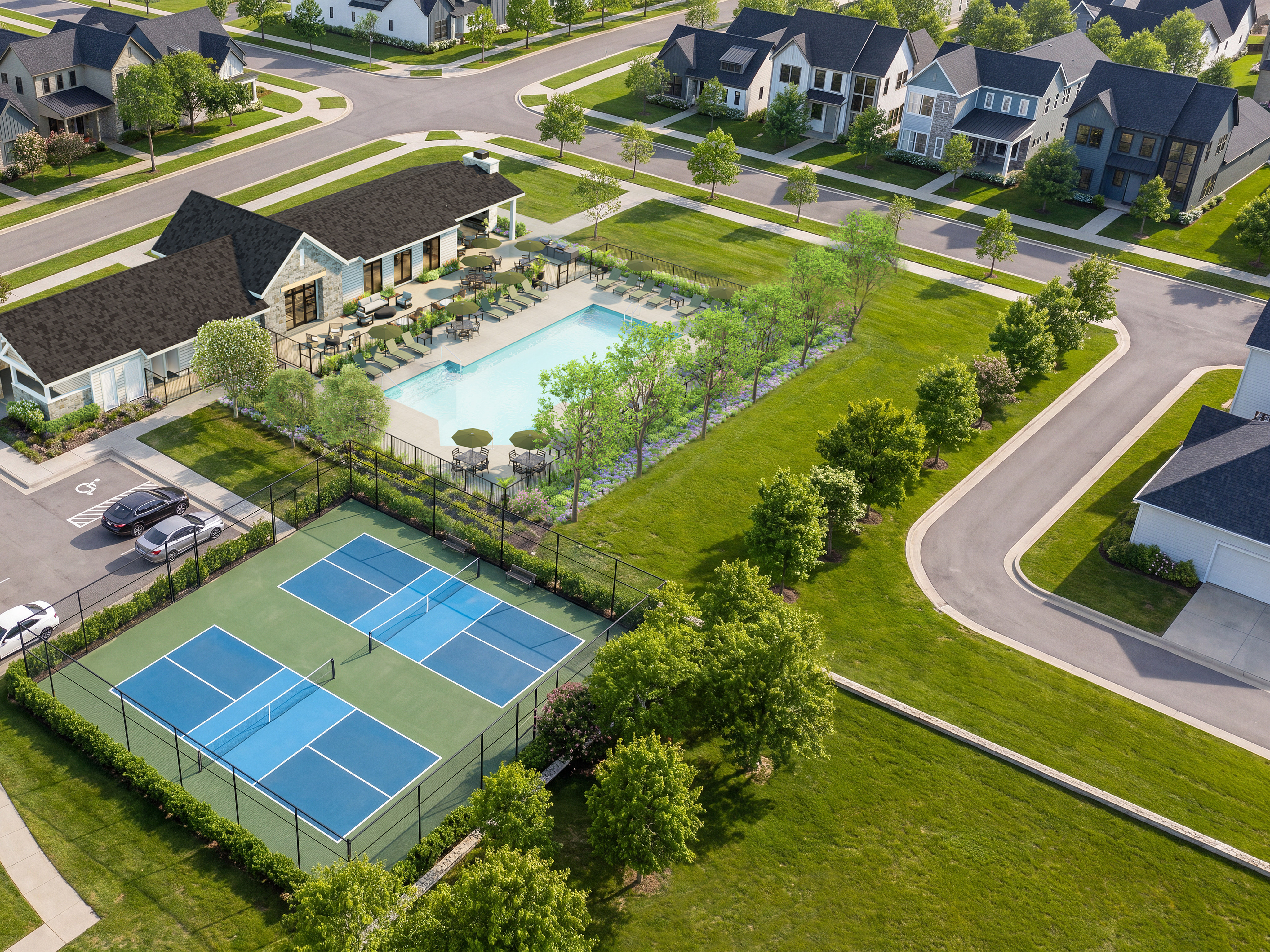 In the foreground, two pickleball courts are visible, while the background features a swimming pool and a cluster of houses.