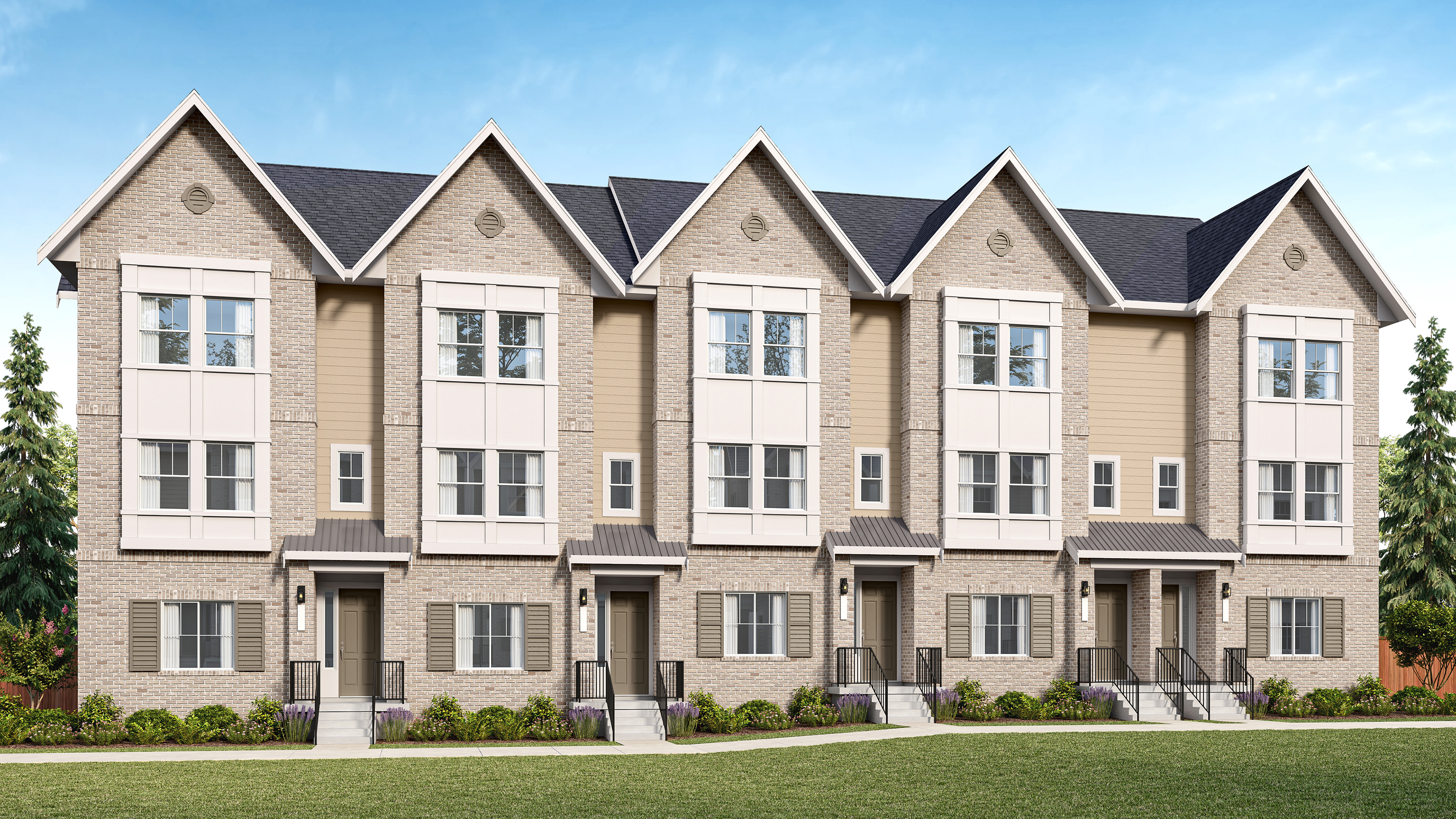 A row of modern townhouses with light brick facades and dark roofs stands on a manicured lawn under a clear blue sky.