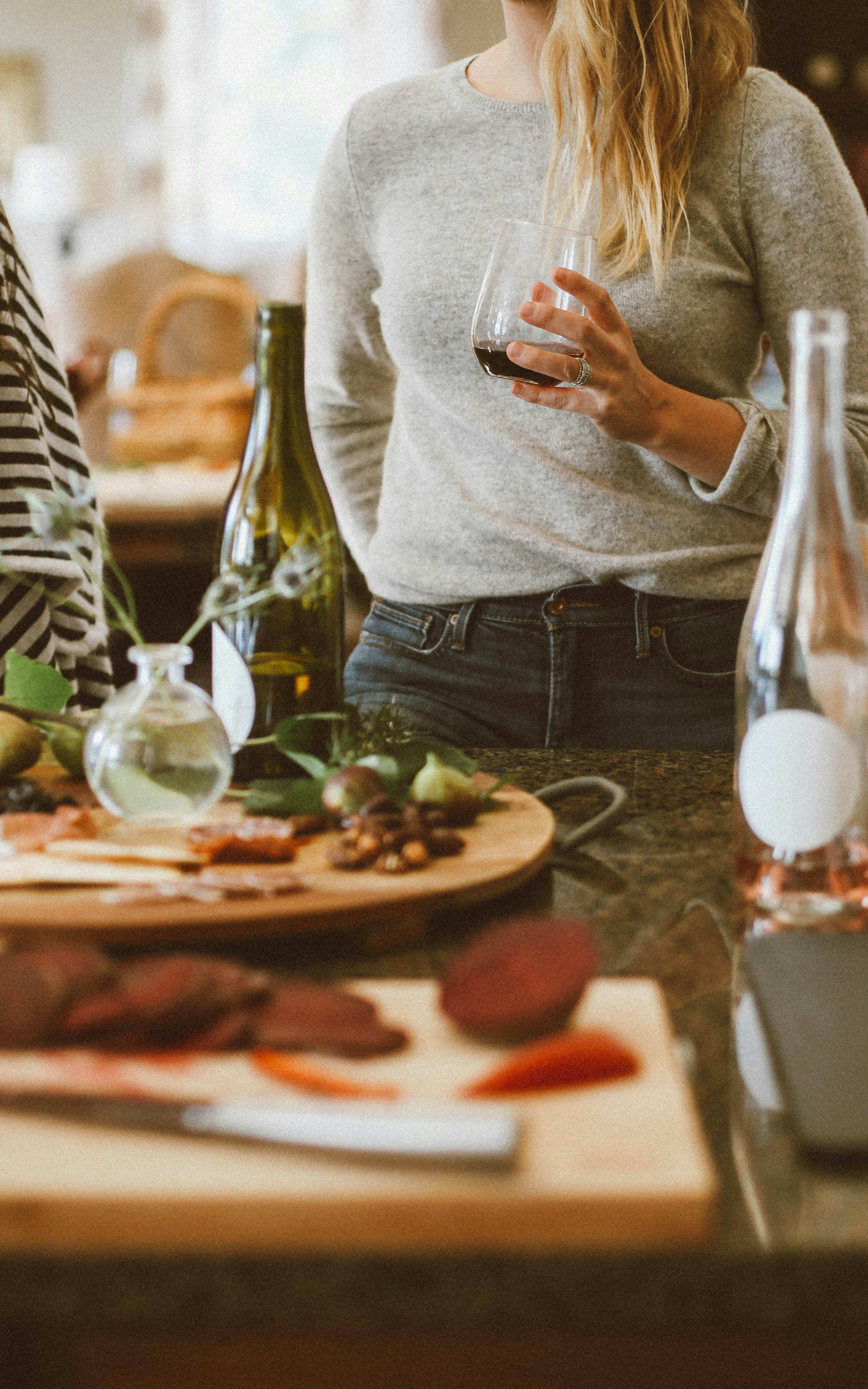 A cozy gathering of friends enjoying a meal together, with a table full of delectable dishes and drinks in a warm, inviting setting.