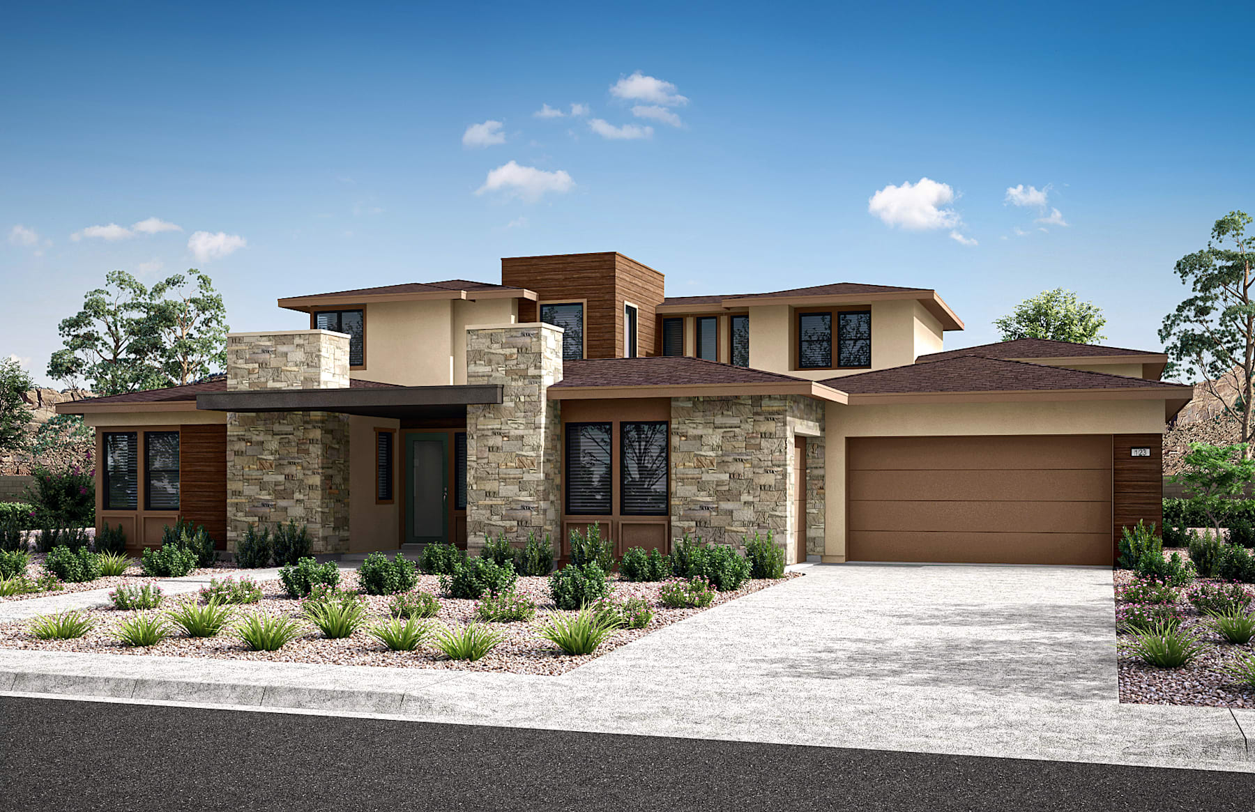 A modern two-story house with a stone and stucco exterior, surrounded by a well-landscaped yard with a paved driveway leading to the garage, set against a clear blue sky with scattered clouds.