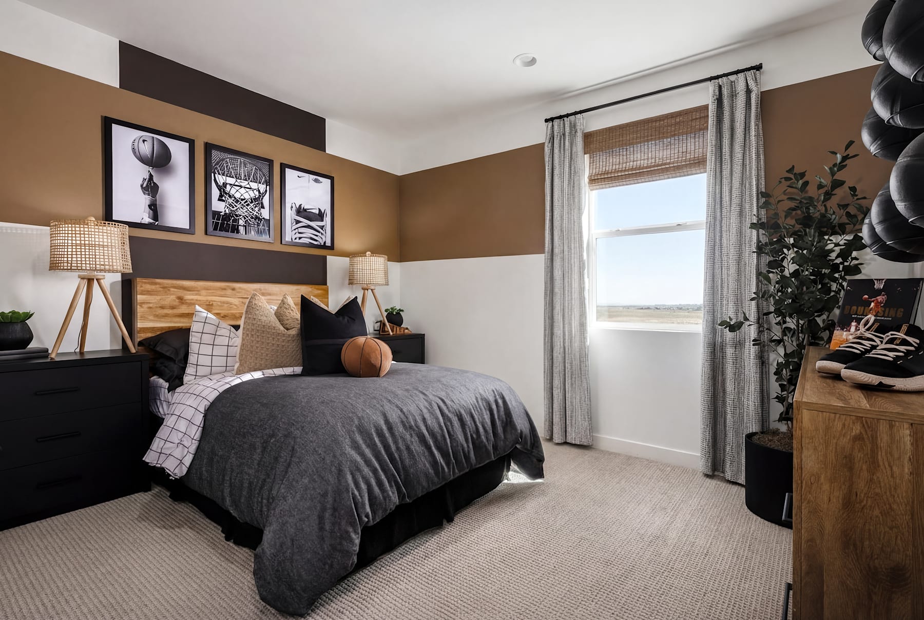 A cozy and stylish bedroom with a large bed, framed artwork on the walls, and a window providing natural light.
