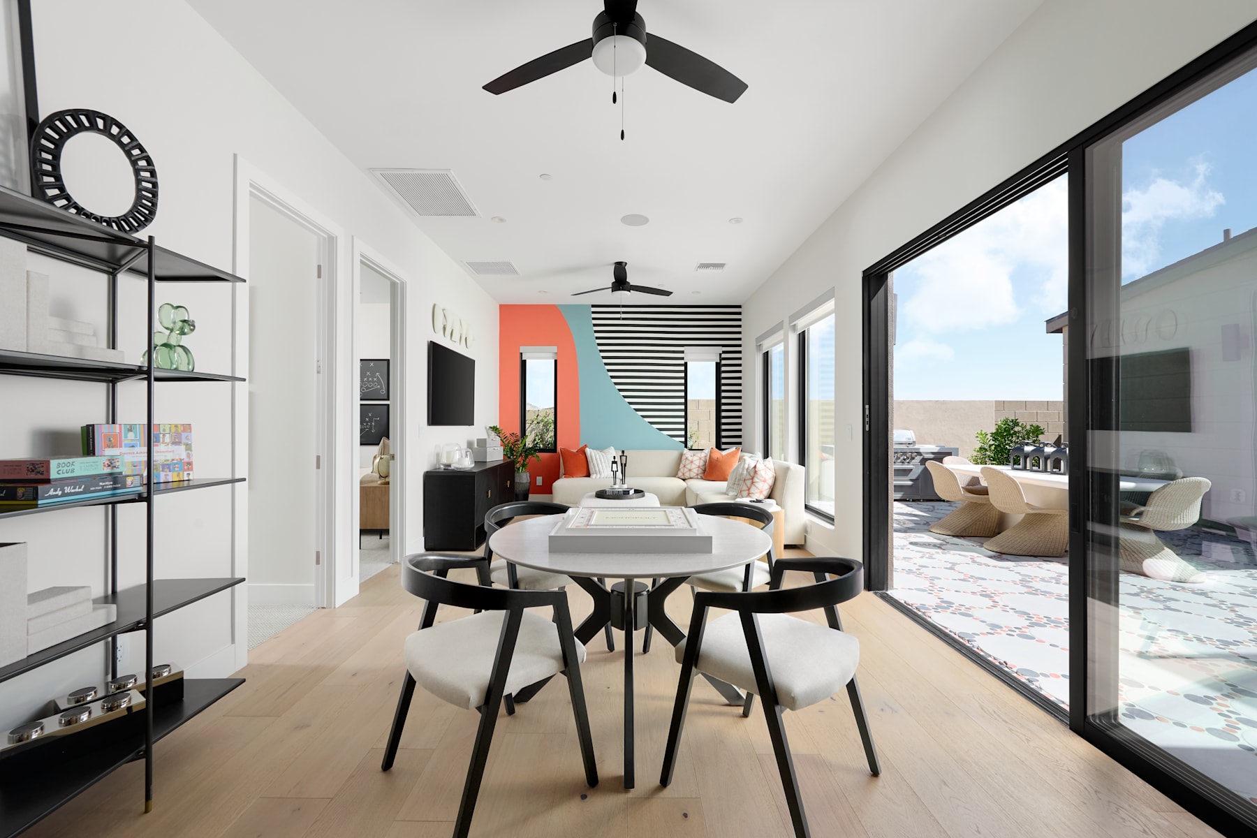 A modern and minimalist living space with a dining area, featuring a white and black color scheme, sleek furniture, and large windows providing natural light.