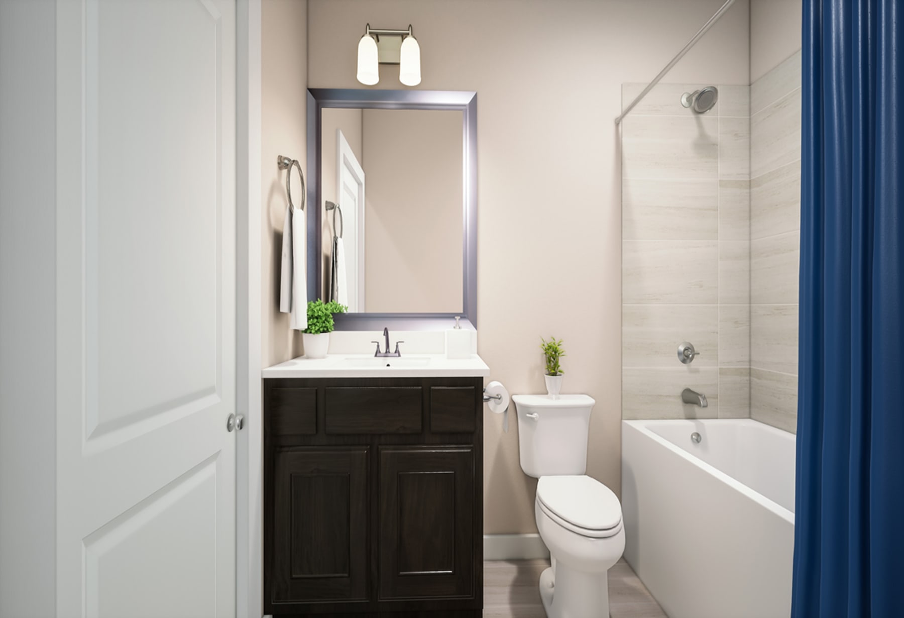 A modern bathroom with a dark wood vanity, a white toilet, and a bathtub surrounded by white walls and a blue curtain.