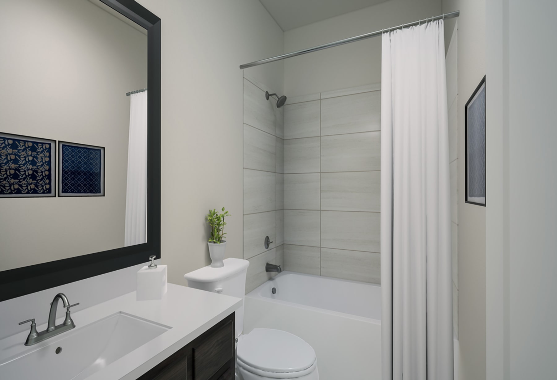 A modern, minimalist bathroom with a white vanity, toilet, and a shower curtain covering the bathtub. The walls are painted a light gray, and there are framed artworks on the wall.