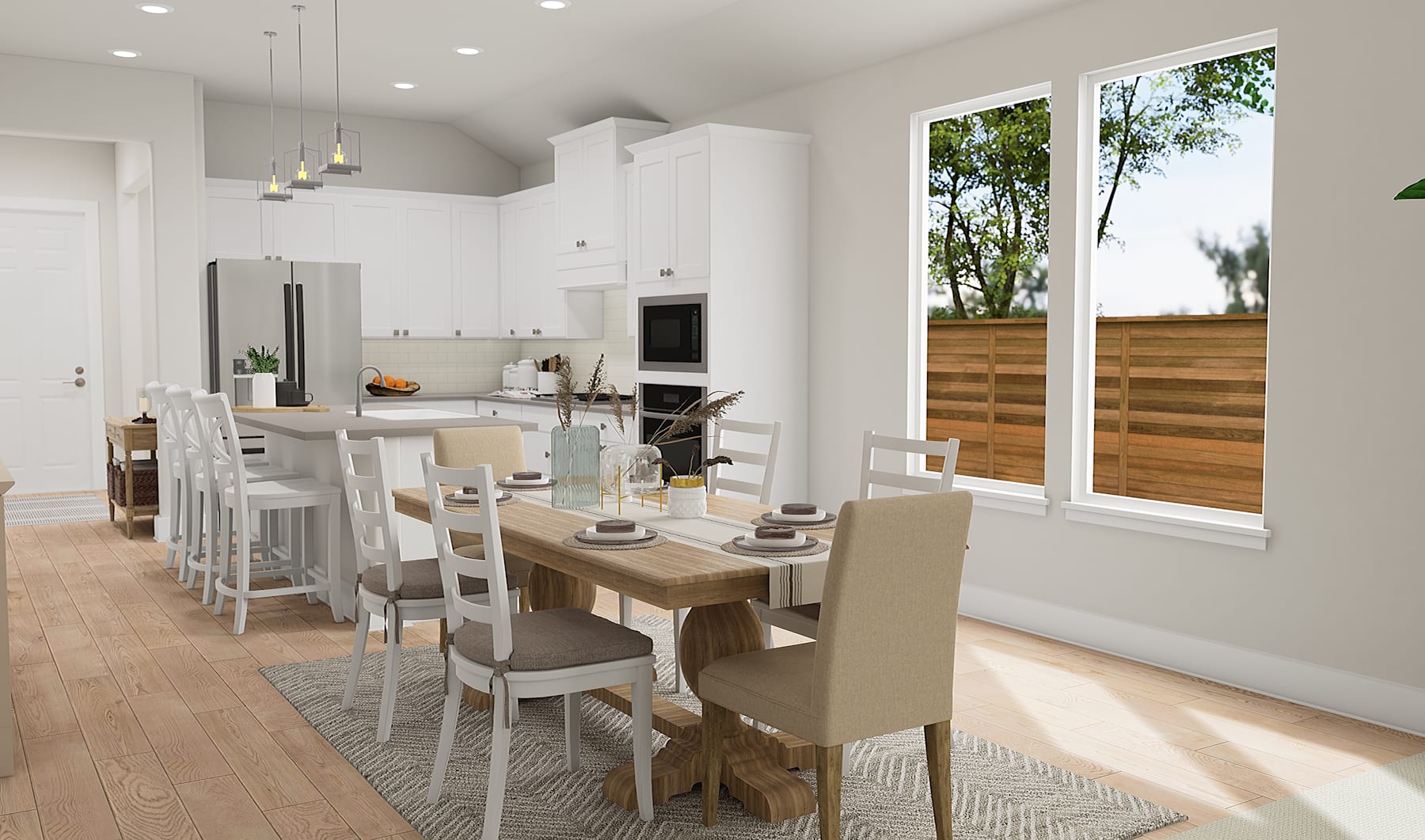 A modern, open-concept kitchen and dining area with a wooden table, white chairs, and large windows overlooking a backyard with trees.