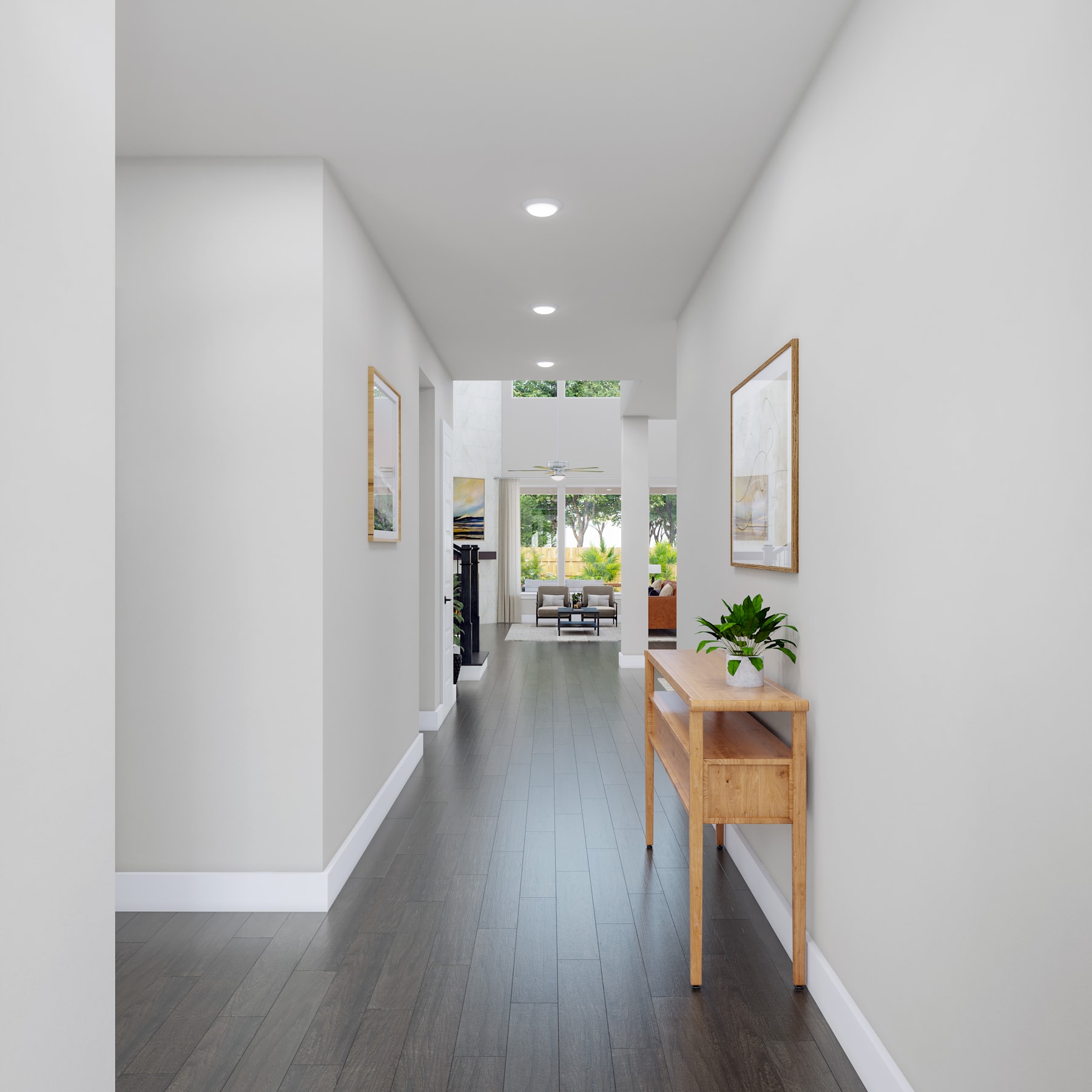 A bright, minimalist hallway with white walls, dark hardwood floors, and a wooden console table in the foreground, leading to a view of the outdoors through a glass door in the background.