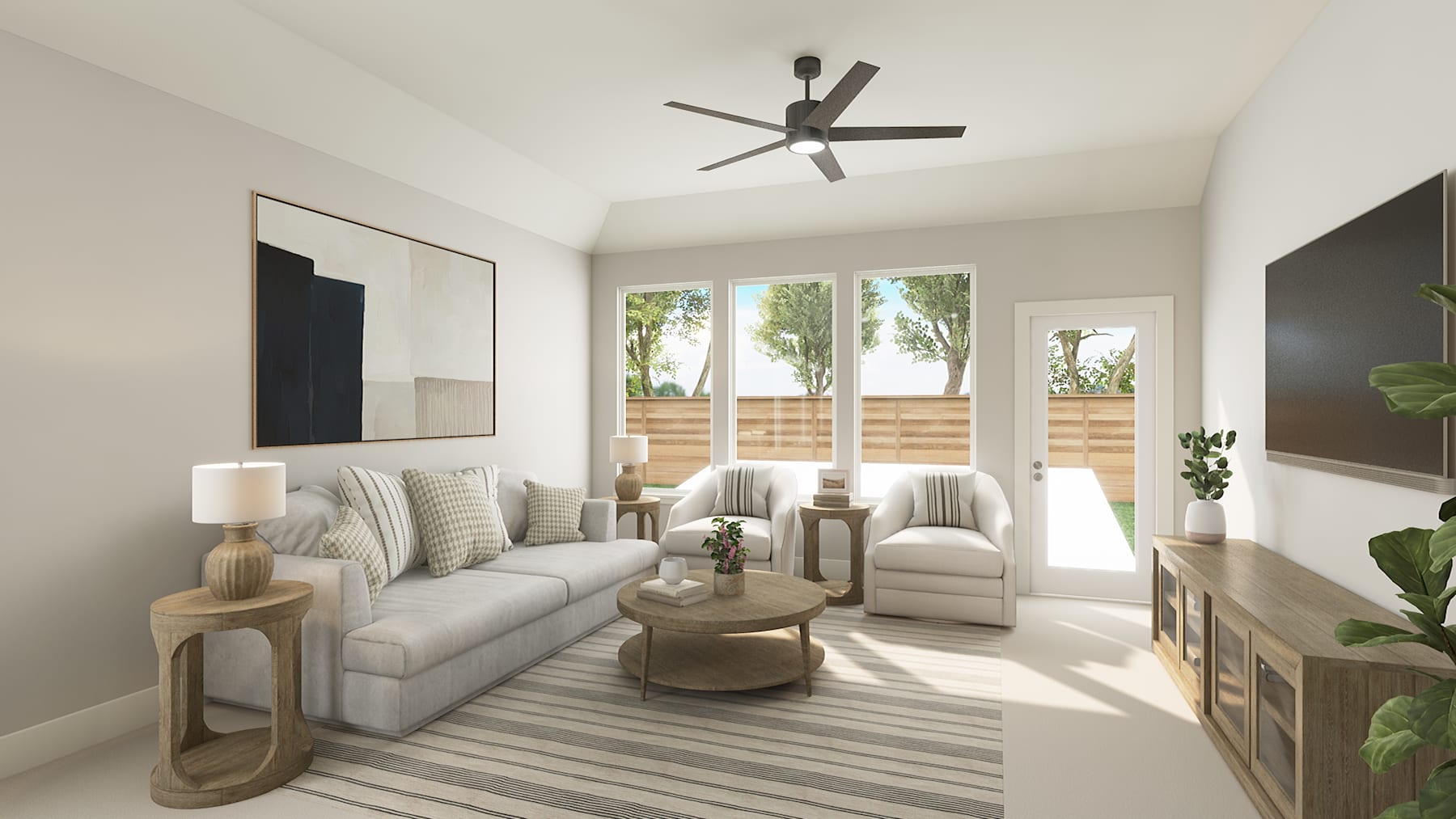 A cozy and well-lit living room with a gray sofa, wooden side tables, and a ceiling fan, surrounded by large windows overlooking a lush outdoor environment.