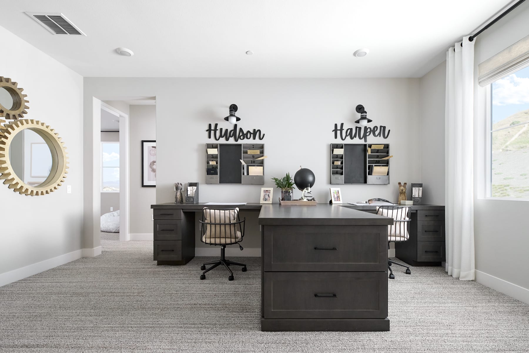 A modern and minimalist home office space with dark furniture, wall decor, and a bright, airy atmosphere.