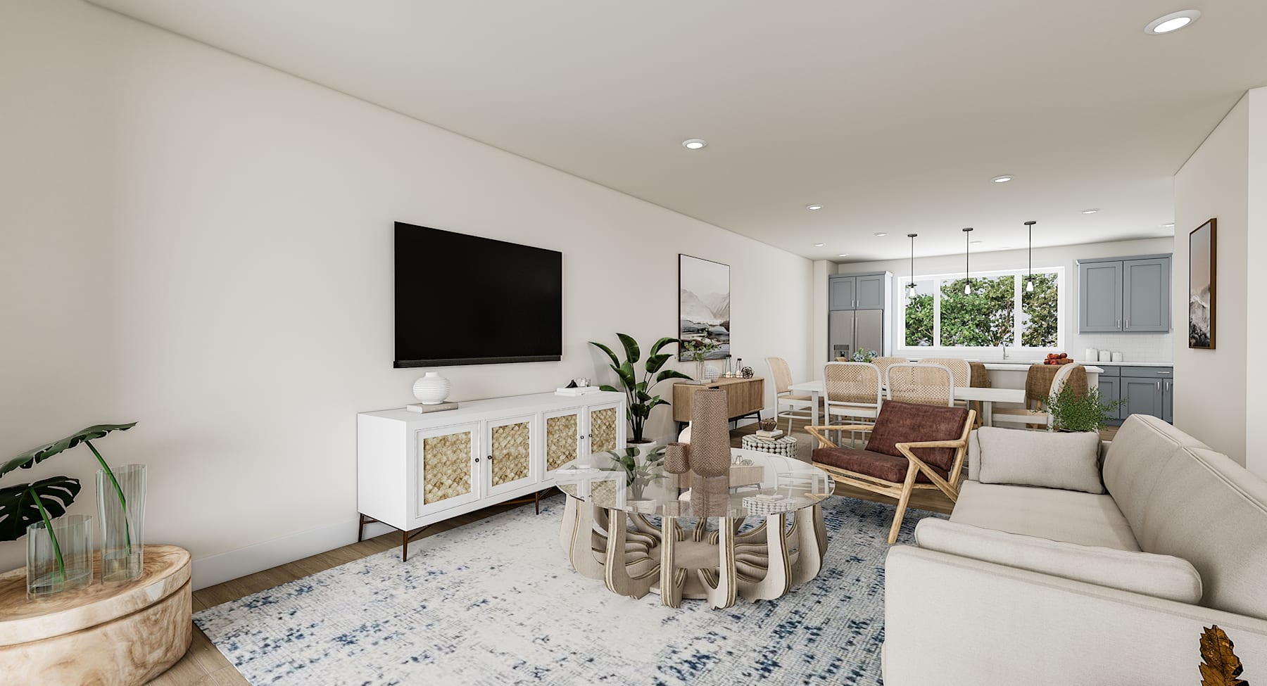 A cozy and well-furnished living room with a large TV, a wooden dining table, and a comfortable sofa set against a backdrop of large windows overlooking greenery.