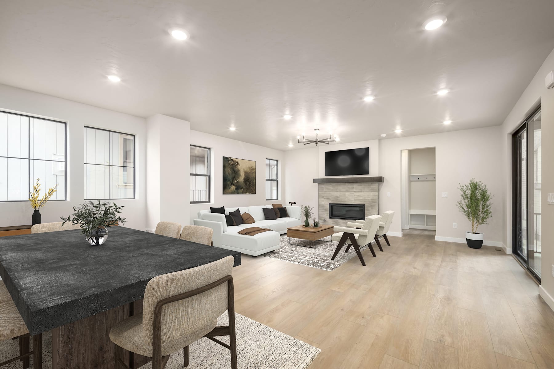 A spacious and modern living room with a large dining table, comfortable seating, a fireplace, and abundant natural lighting from the windows.